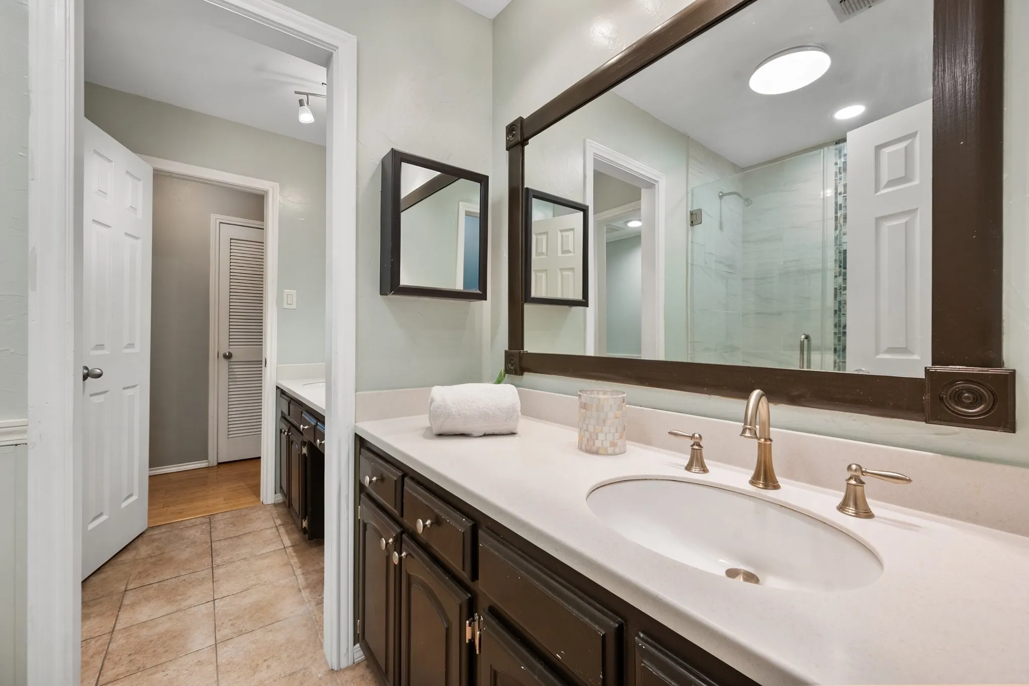 Renovated secondary bathroom features an updated vanity, tiled tub and shower surround, and a bright, clean finish