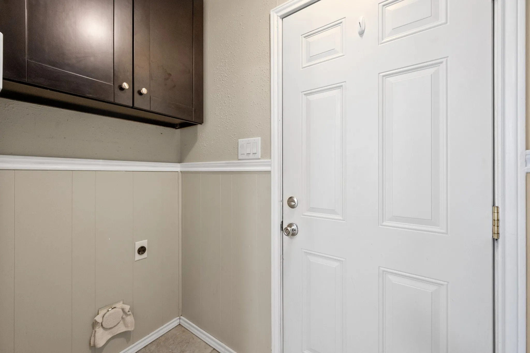 Dedicated laundry area provides additional upper cabinetry for convenient household storage.