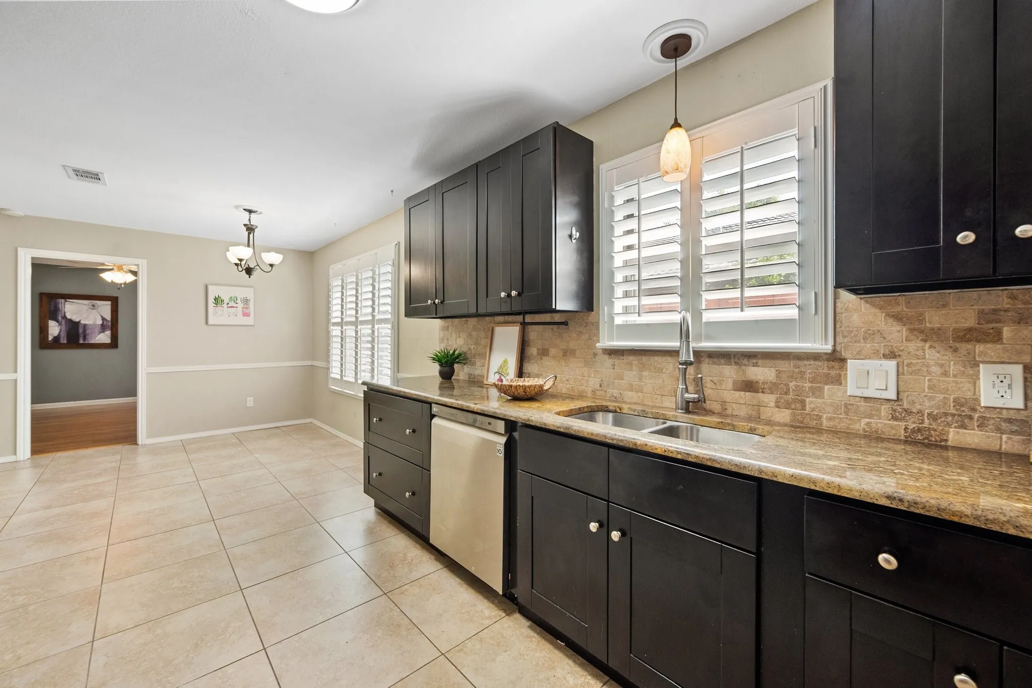 A second kitchen view showcases the granite countertops, stainless steel appliances, extensive cabinetry, and adjoining dining space.