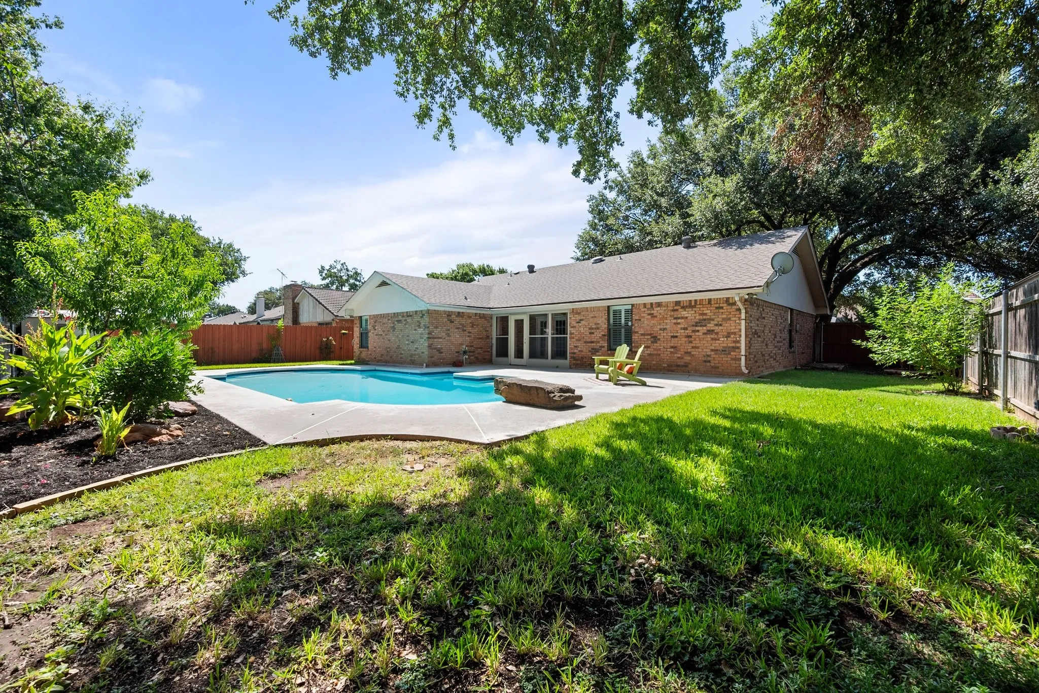 There’s more to this backyard than the pool—mature trees, established landscaping, and additional lawn space provide plenty of ways to enjoy the outdoors.