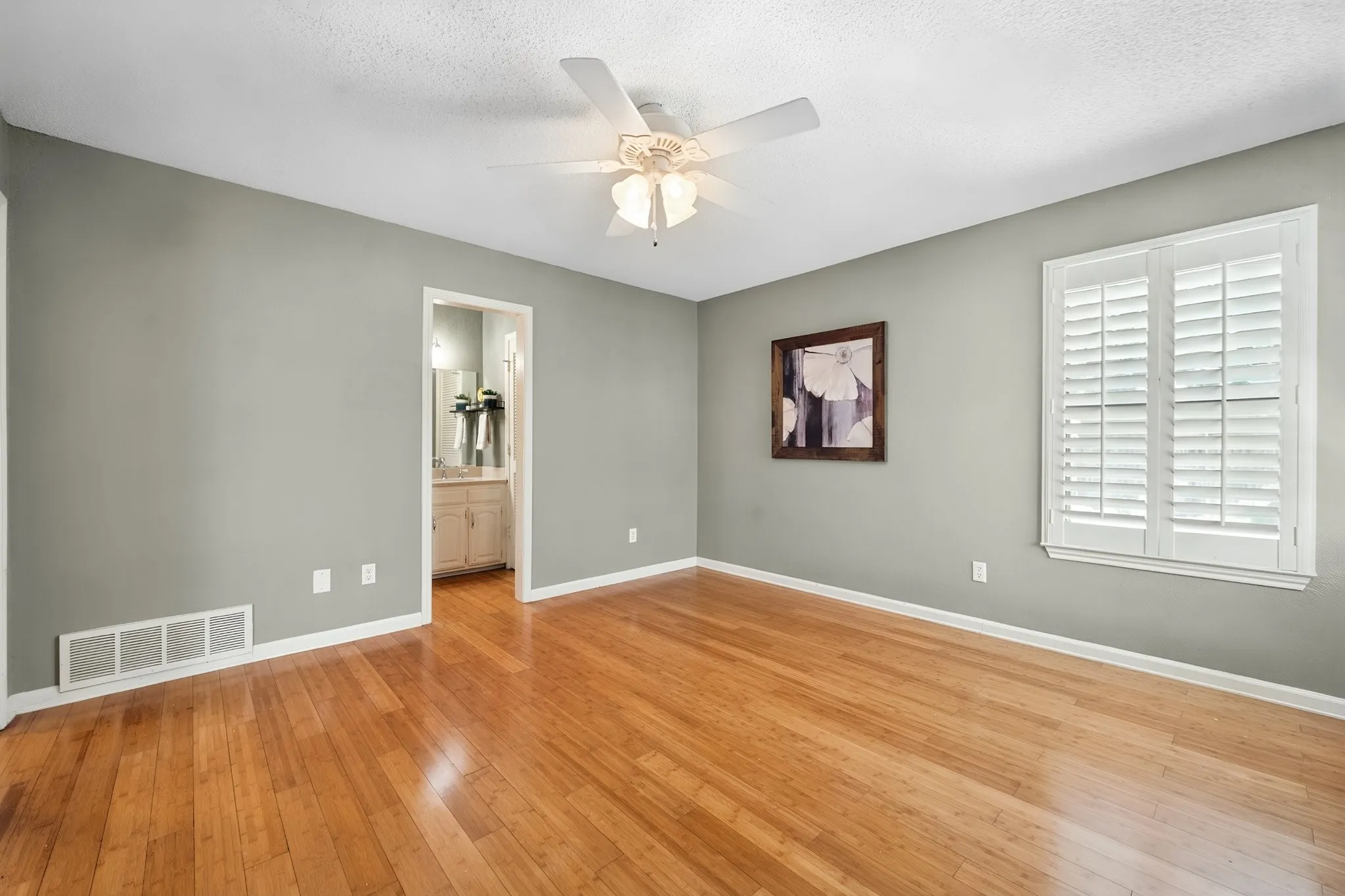 Spacious primary bedroom offers plenty of flexibility for a full bedroom setup, sitting area, or additional workspace.
