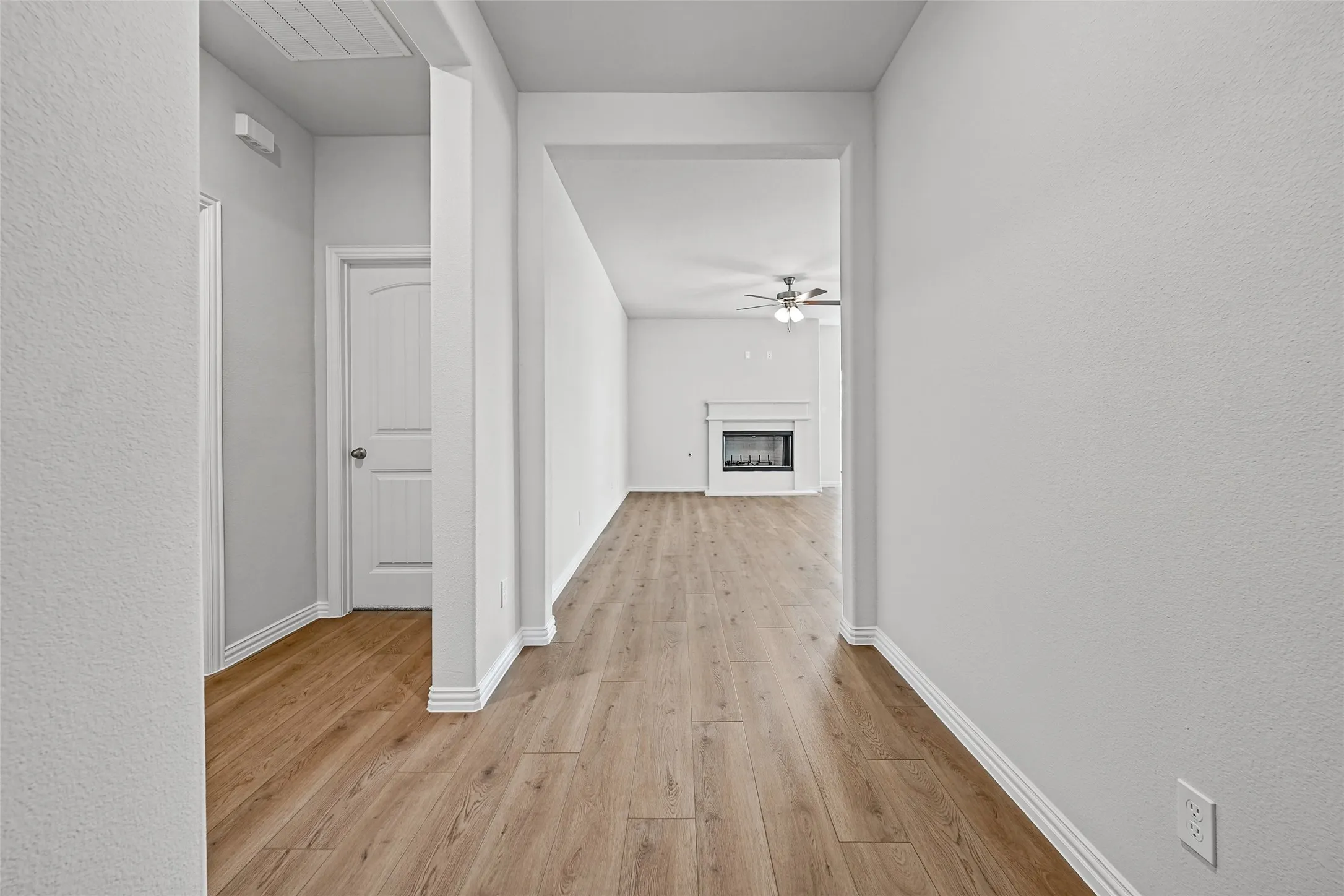 Wood-finish flooring throughout, white interior walls, decorative trim, and white paneled doors