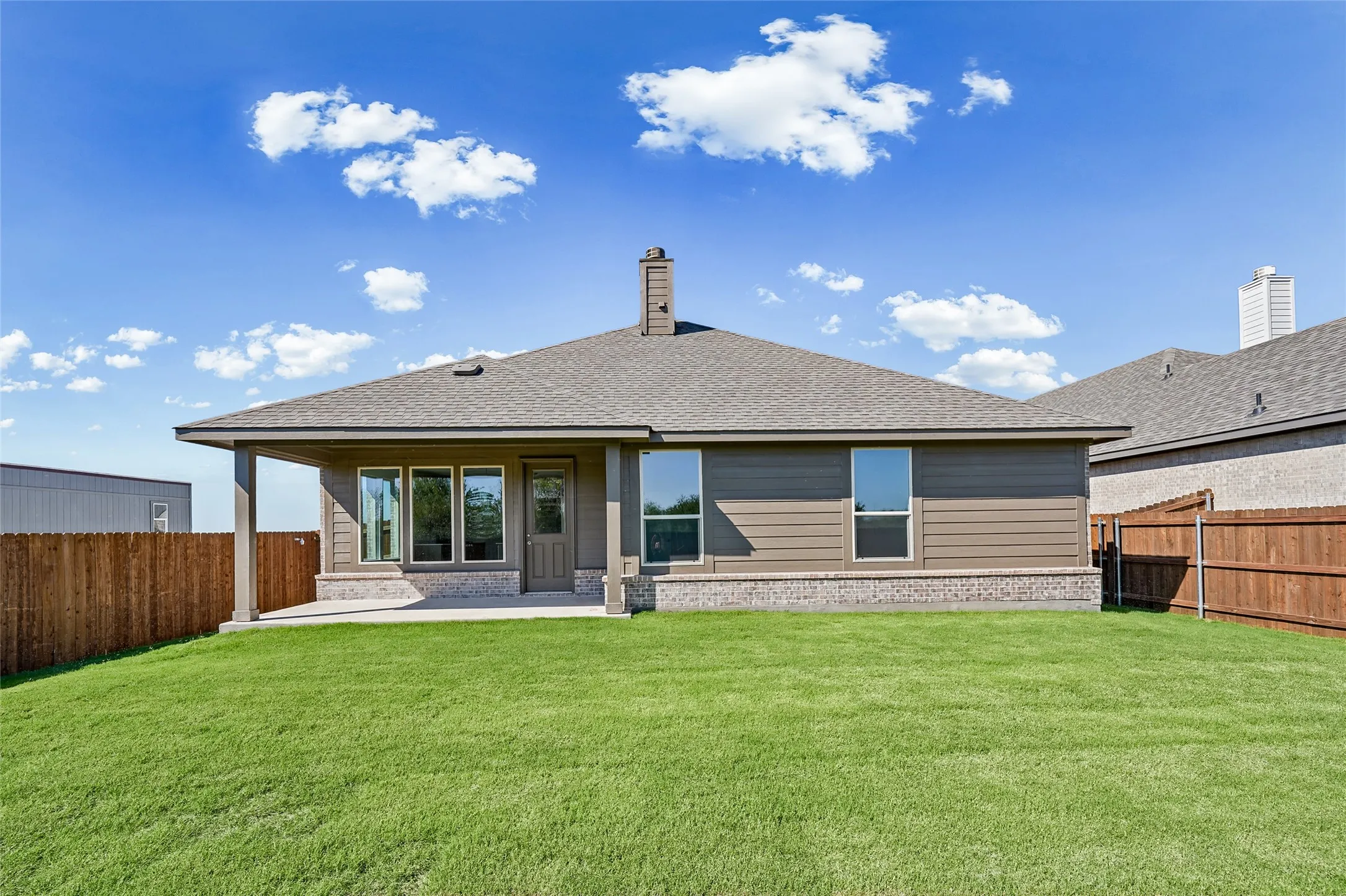 Expansive green lawn with a covered patio