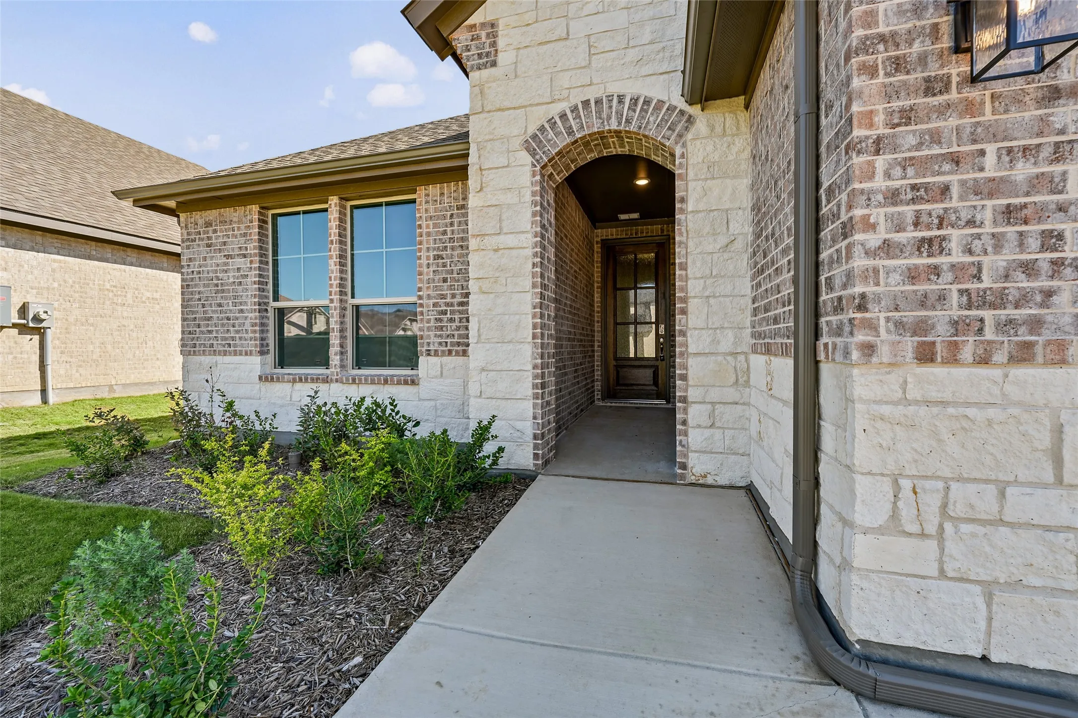 Brick and stone facade with an arched​​‌​​​​‌​​‌‌​‌‌​​​‌‌​‌​‌​‌​​​‌​​ entryway