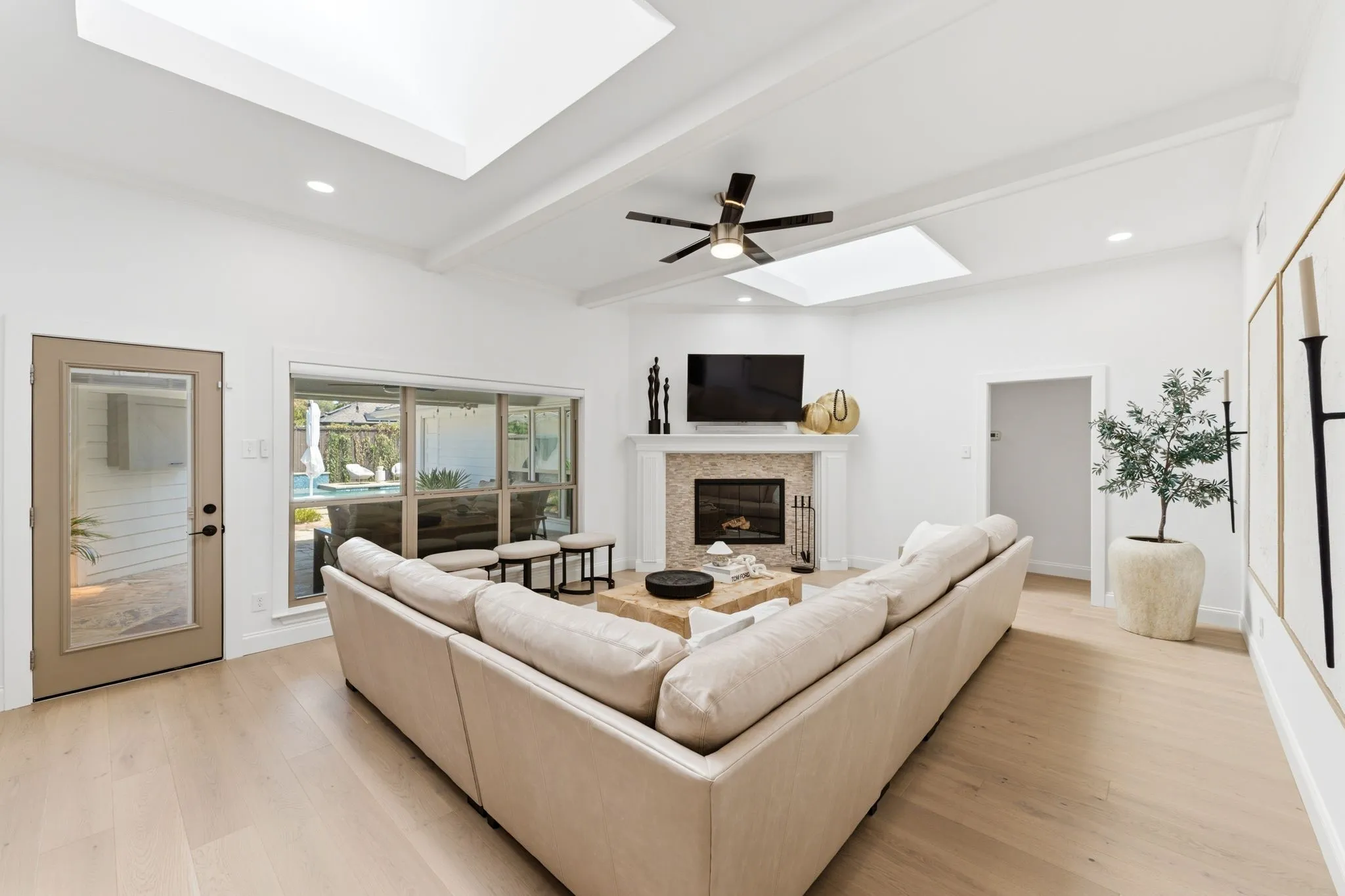 Living room with fireplace, skylight, and access to porch