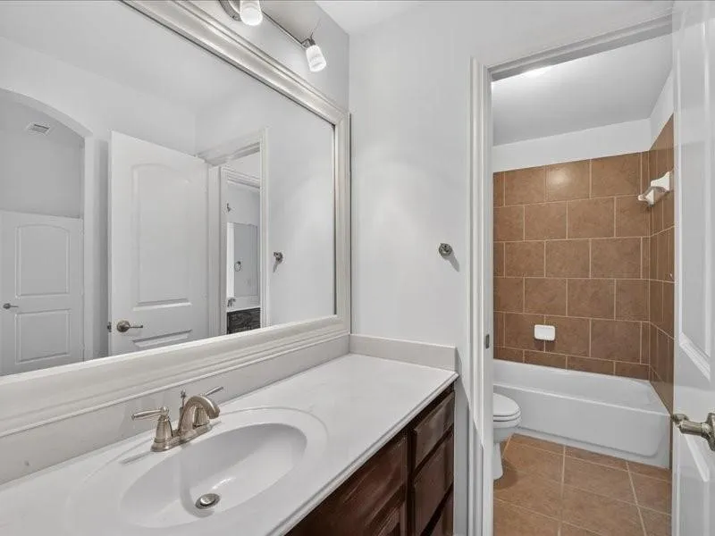 Vanity with an integrated sink, brushed nickel faucet, and a large framed mirror