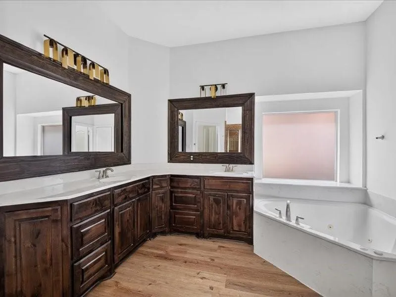 Dual vanity with dark wood-finish cabinetry, white countertops, and integrated sinks
