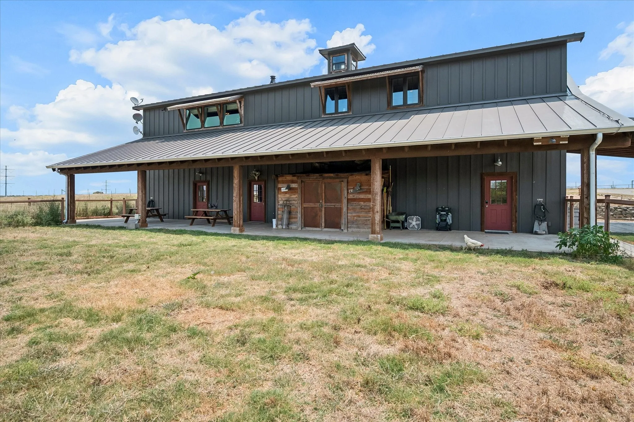The barn has 2 covered porches, this is the one out back with shed and fenced in yard suitable to contain livestock. Fred the chicken says hi! He will great you when your come for a tour. Barn also 3 car garage - heated and cooled - with double garage doors. Charming decorative cupola on top.