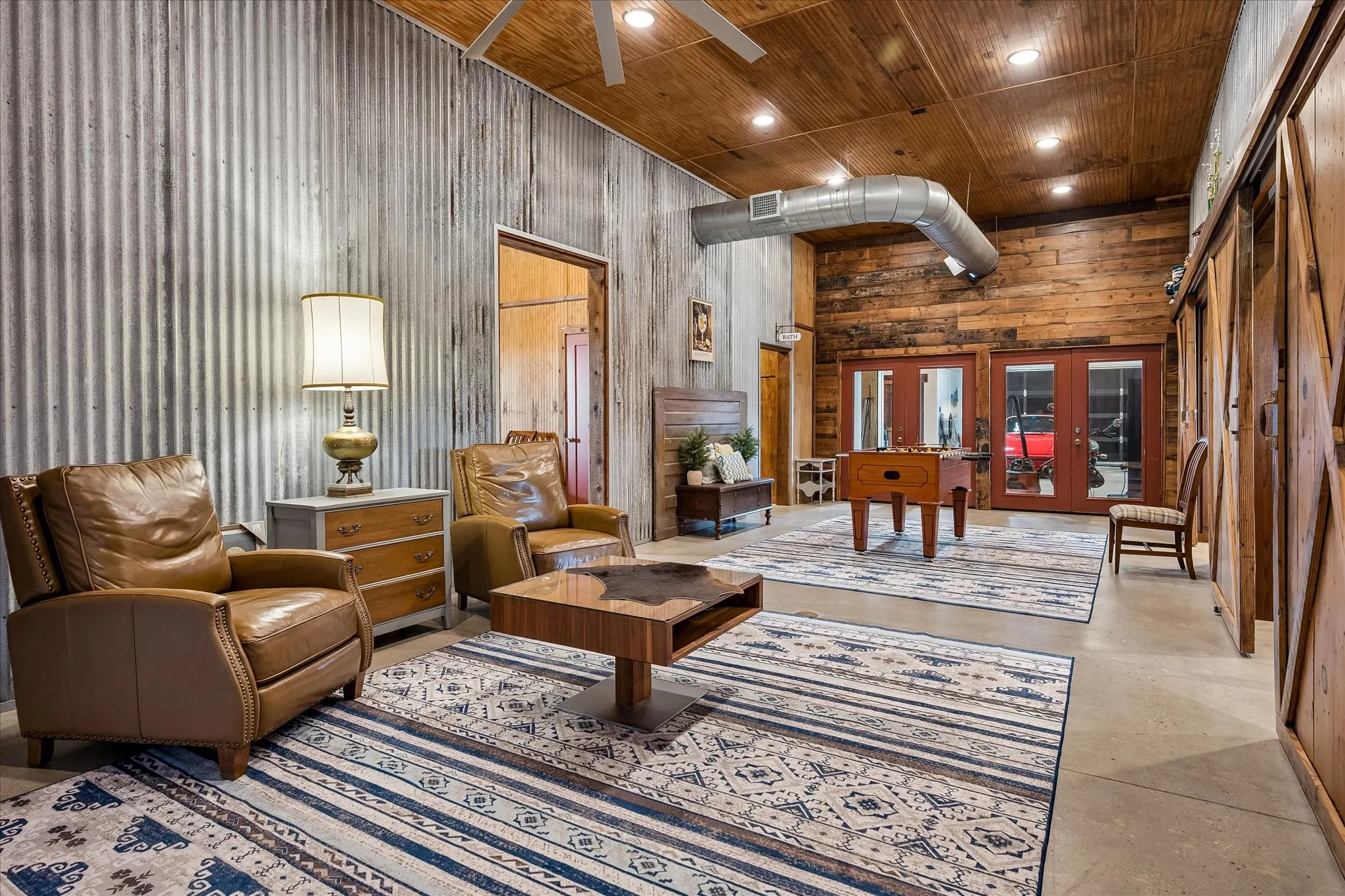 Downstairs living area in the barnominium. Reclaimed wood from an old building in the Fort Worth stockyards throughout the home. Corregated steel walls. 1400 square feet of storage and living space.
