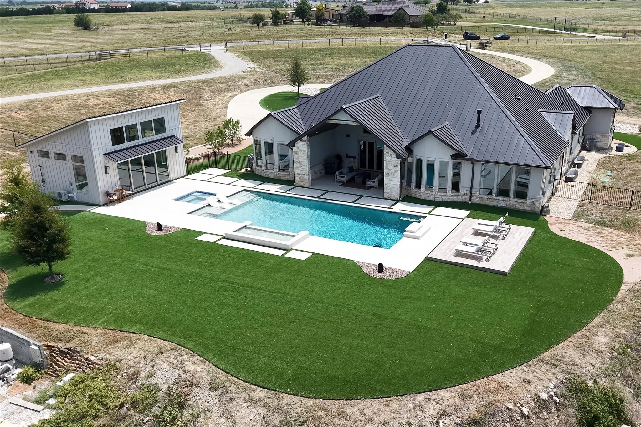 Private pool surrounded by travertine and tuft. Tanning deck, Texas sized covered patio and large pool house with sliding doors that can open all the way when desired.