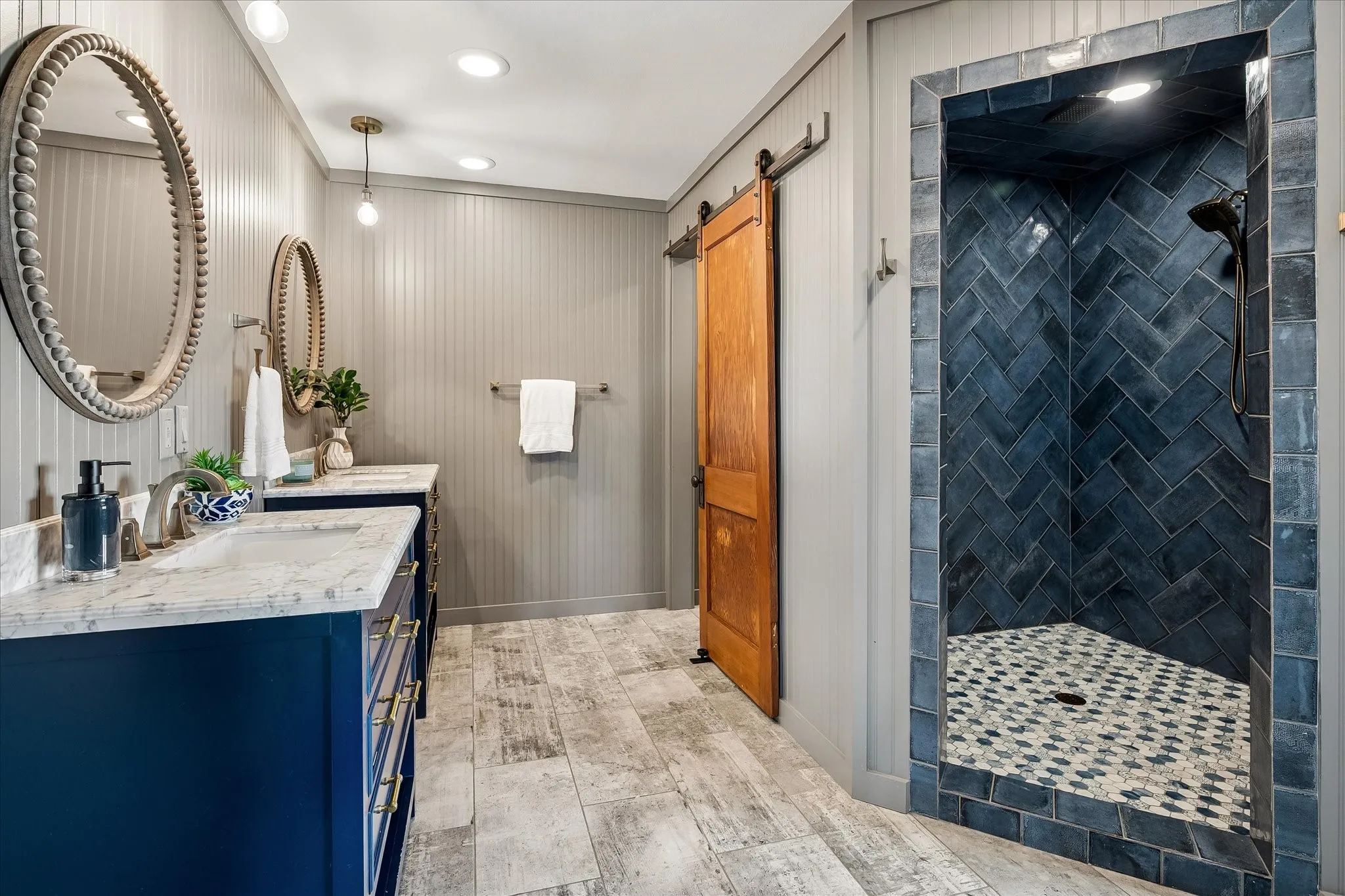 Dual vanities, extra large walk-in shower, champagne gold fixtures, antique barn door with reclaimed hardware.