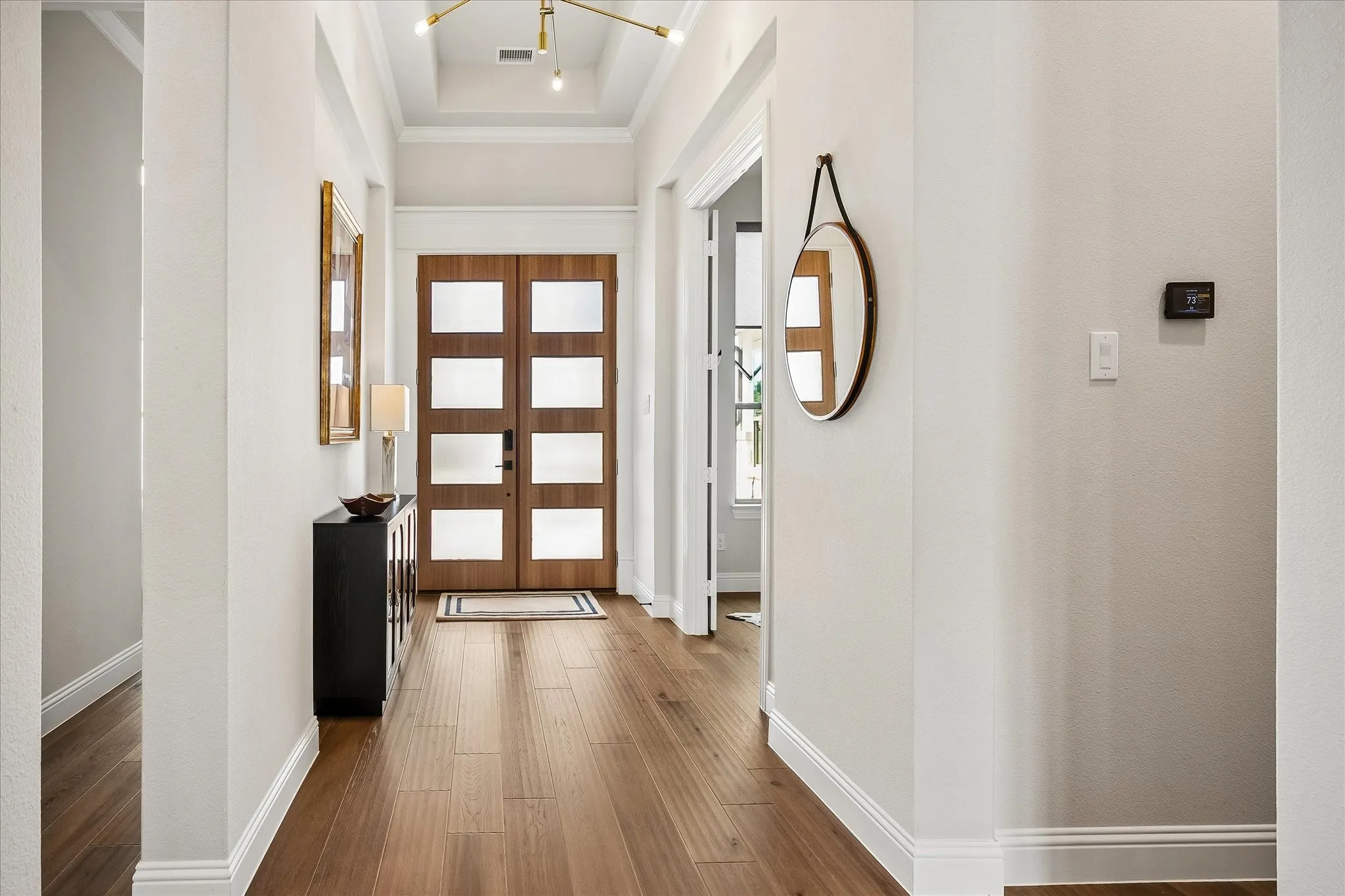 Double wood doors with privacy glass inserts welcome you inside the main house.