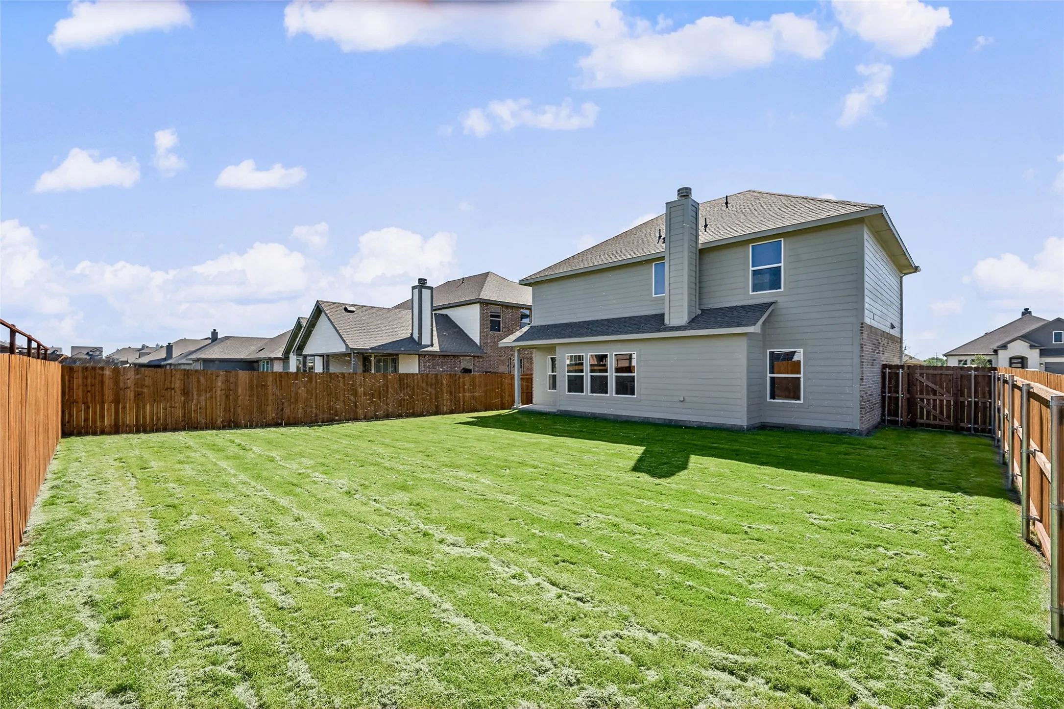 Spacious backyard with a wood privacy fence and a manicured lawn