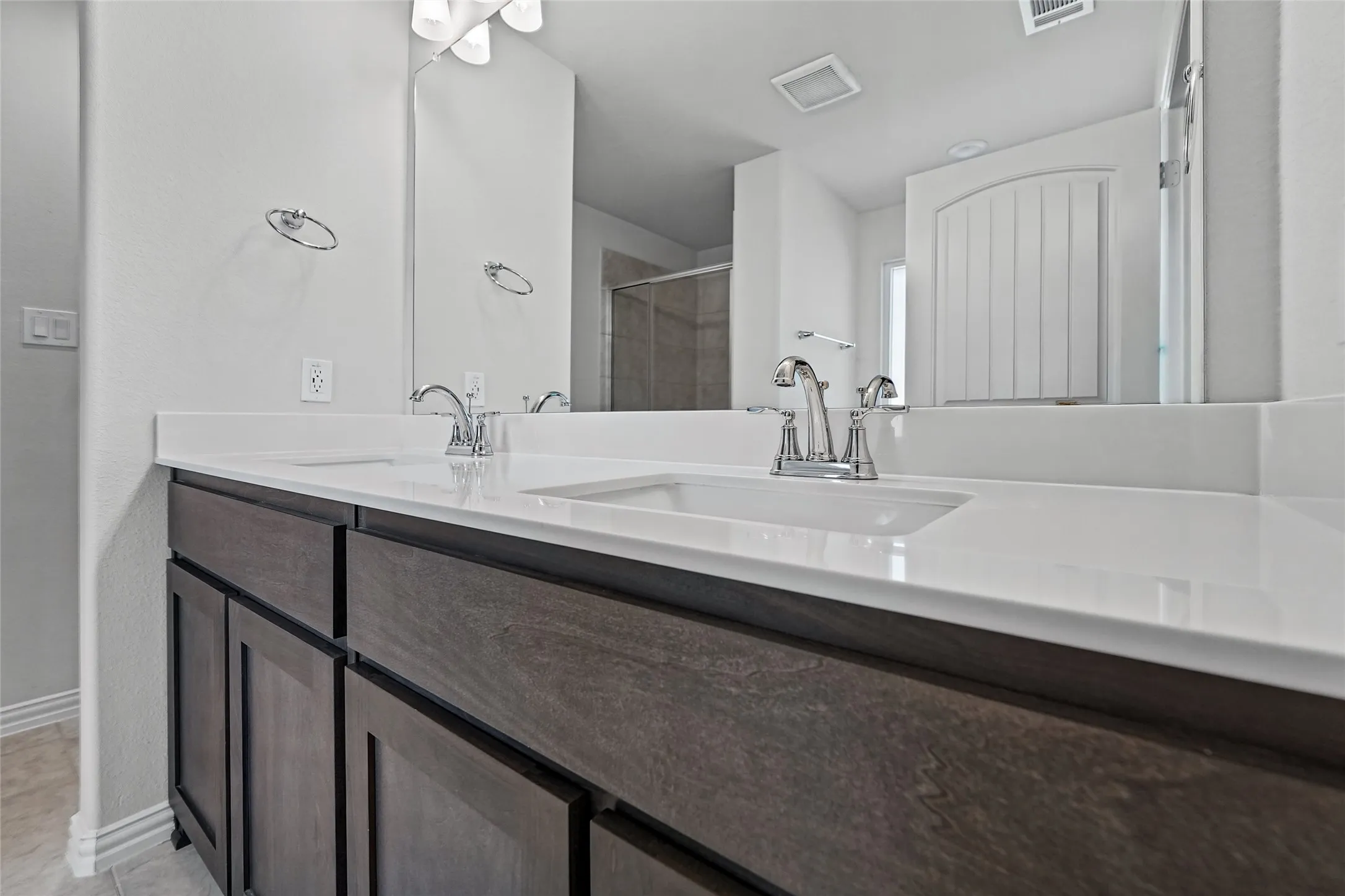 Dual vanity with integrated sinks, chrome fixtures, and a white countertop