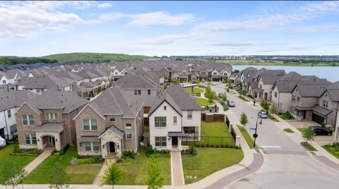 Modern residential community featuring varied architectural styles and a prominent lake