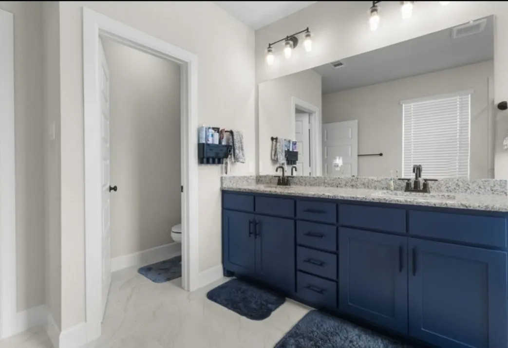 Dual vanity with dark blue cabinetry, light-toned countertop, and undermount sinks