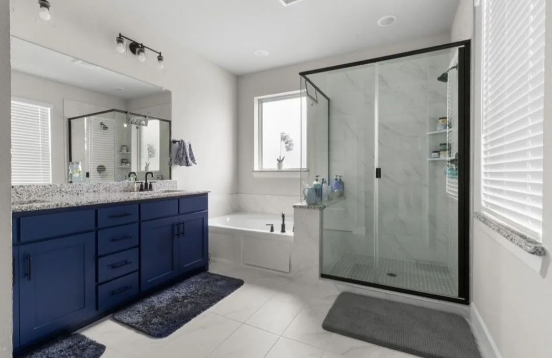 Dual vanity with blue cabinetry and speckled countertop