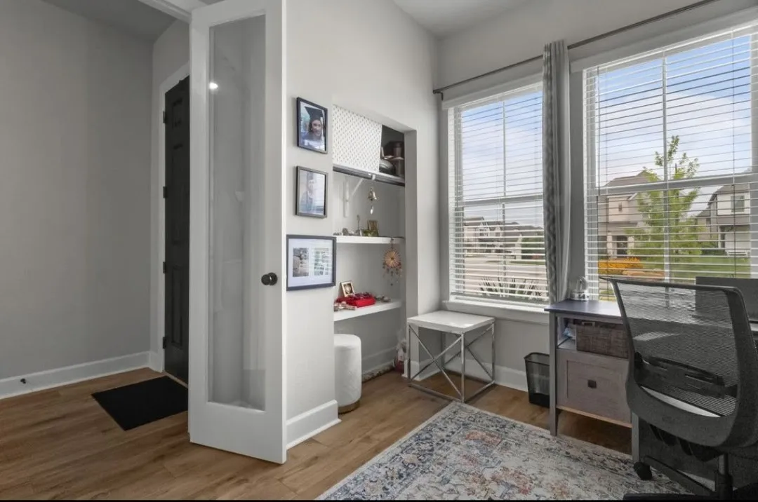 Wood-finish flooring, white trim, and a frosted glass-paneled door