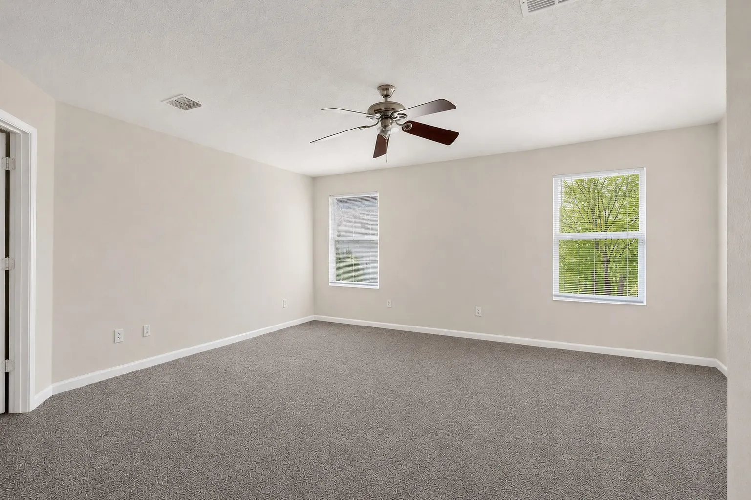 Neutral-toned walls complement the gray carpeting