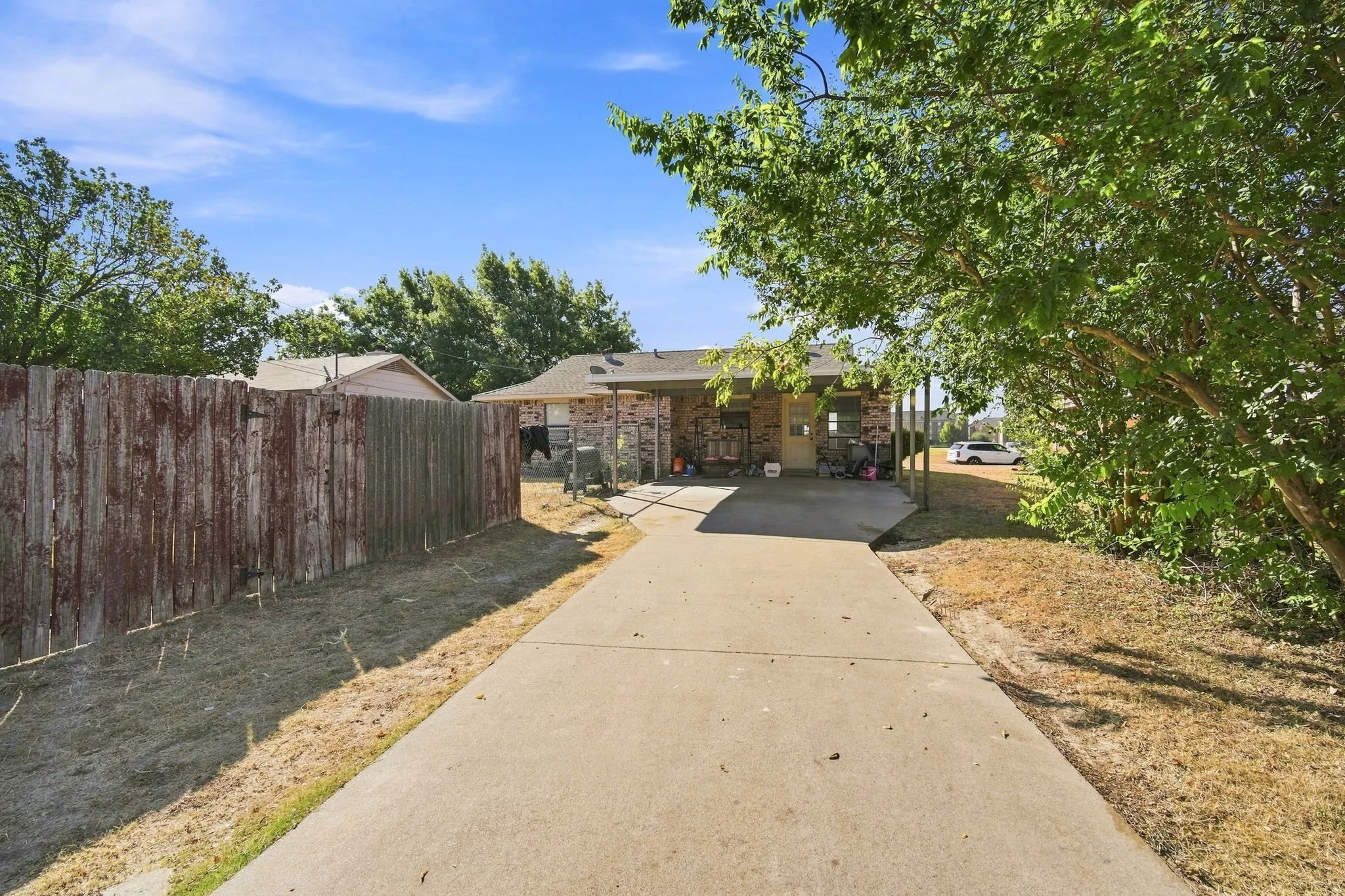 Covered carport in back of home attached to fenced back yard