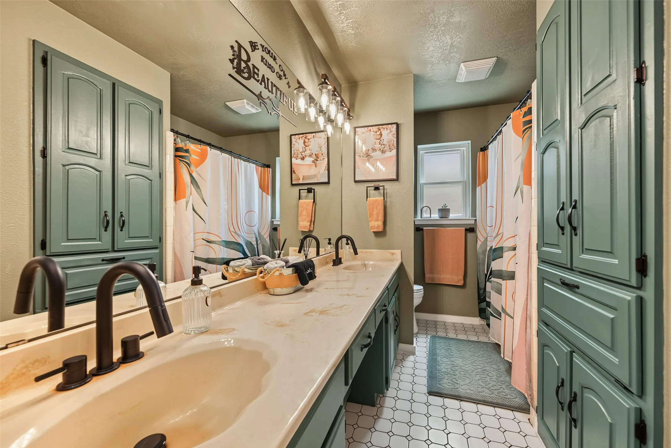 Dual sink vanity featuring a showrer/tub combo and ample storage