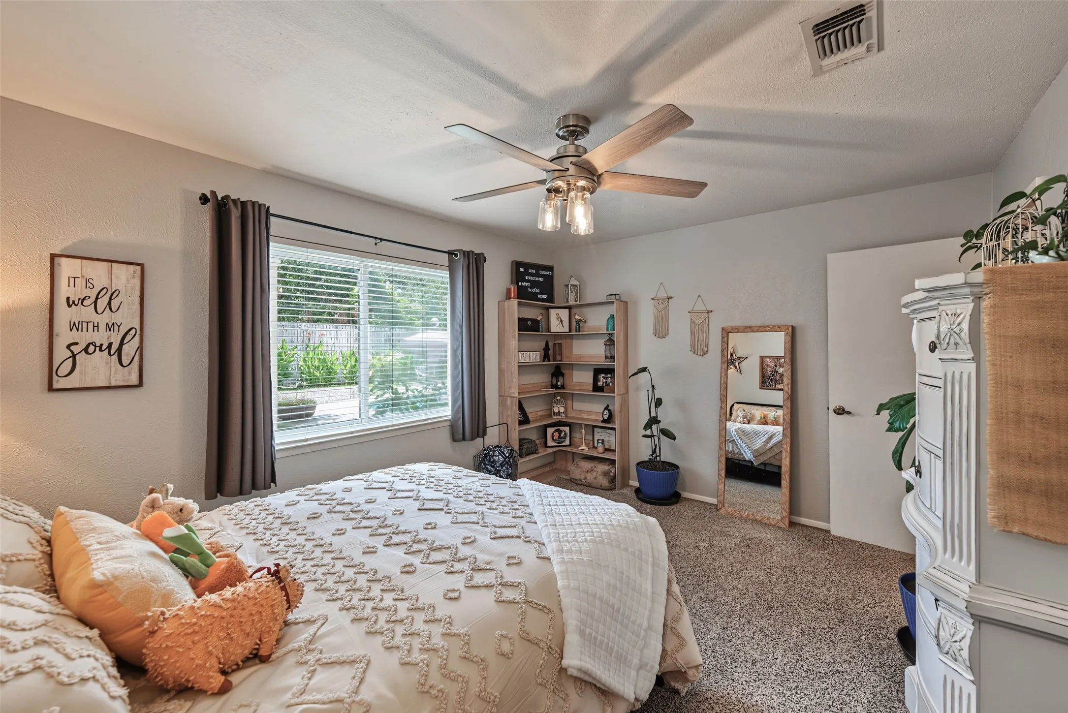 Bedroom with natural lighting, ceiling fan and plush carpet and walk in closet