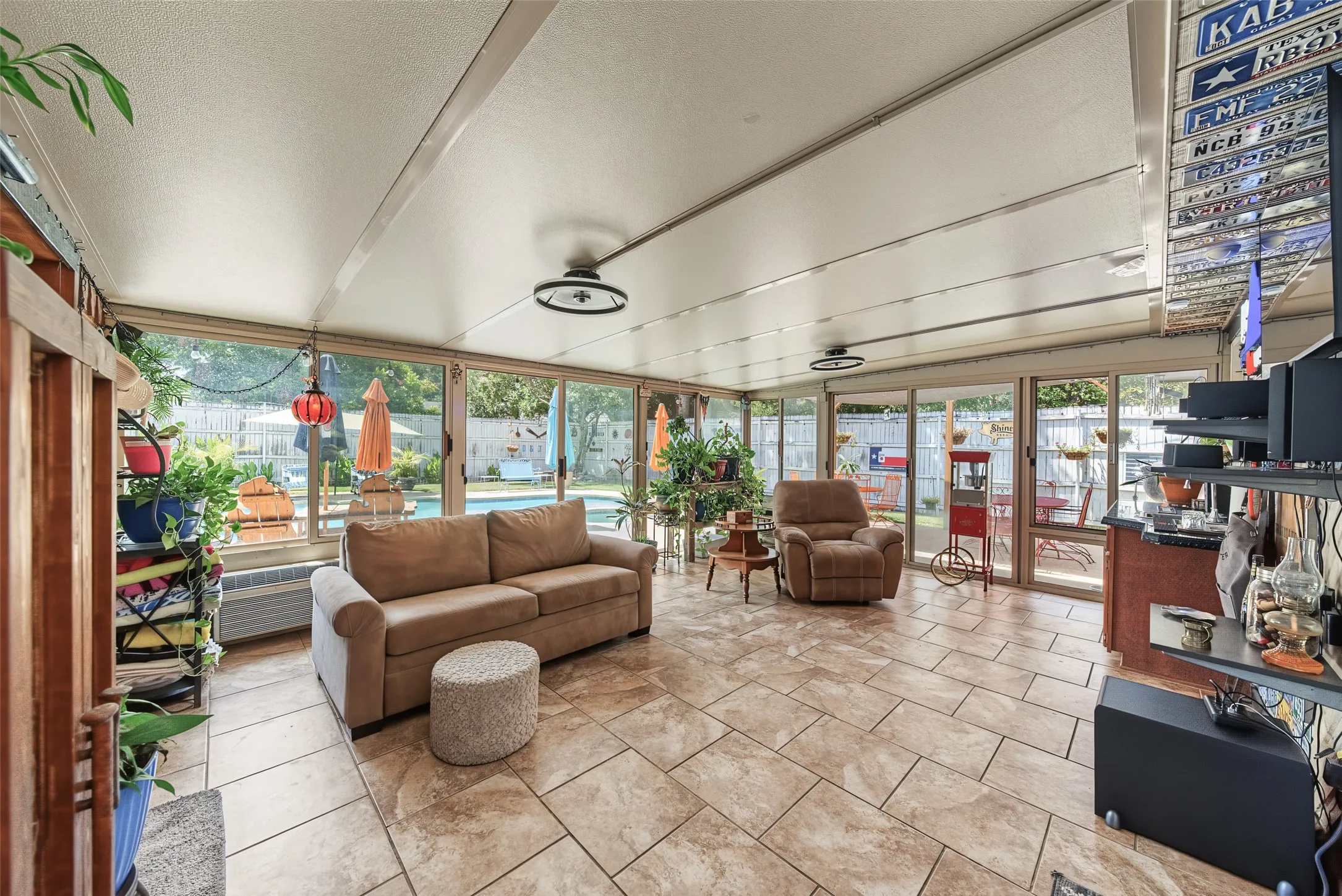 Climate control sun room featuring tiled flooring, 2 mini-splits, and 2 ceiling fans, perfect for entertaining or relaxing