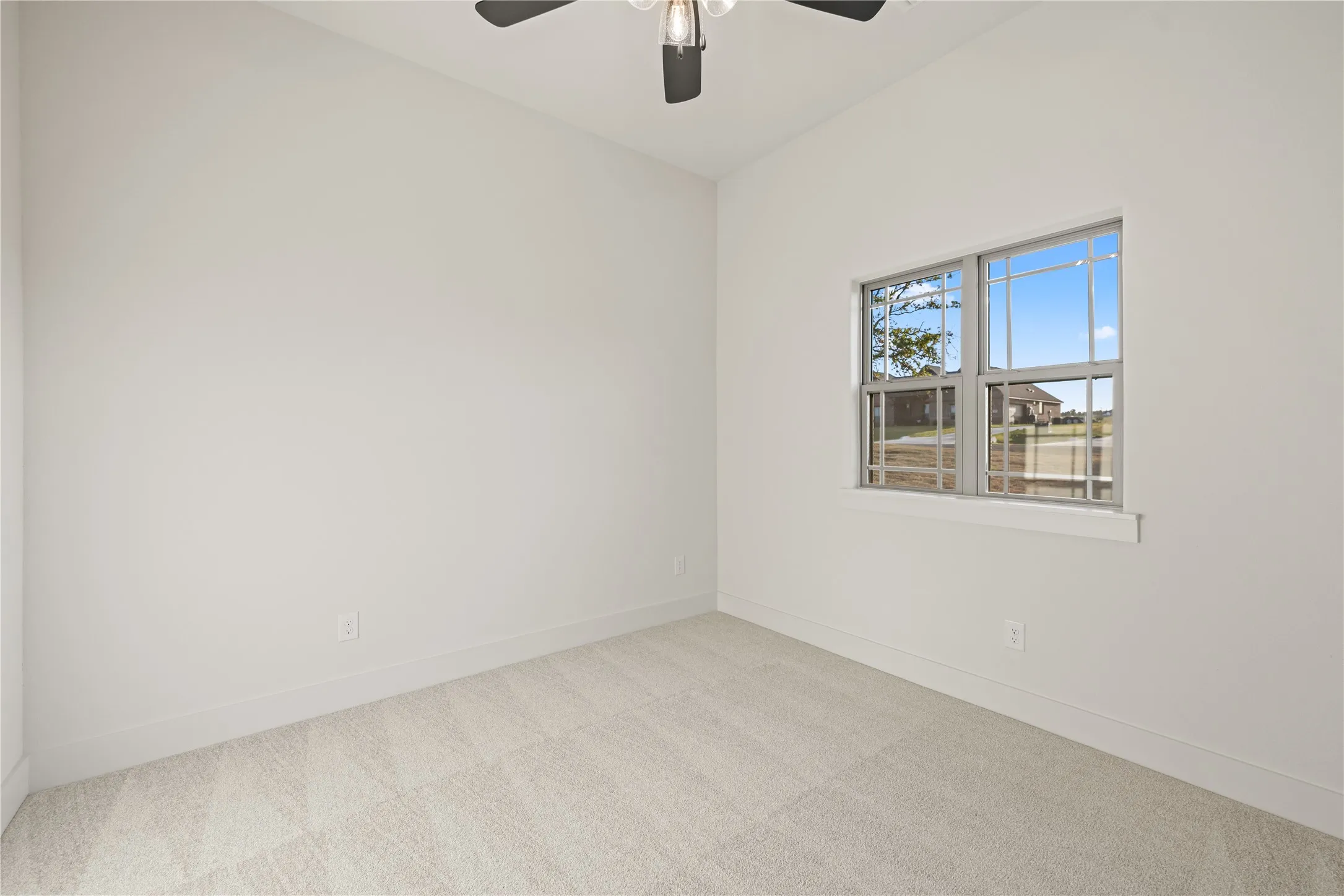 Neutral-toned carpeting, white painted walls, and a multi-pane window