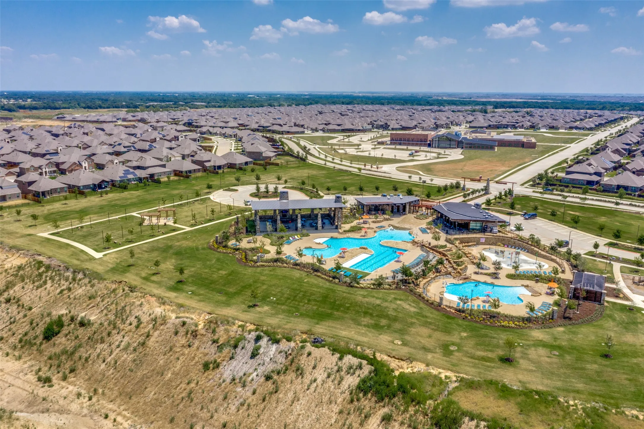 Community amenities featuring multiple swimming pools, a central clubhouse, and dedicated recreational areas