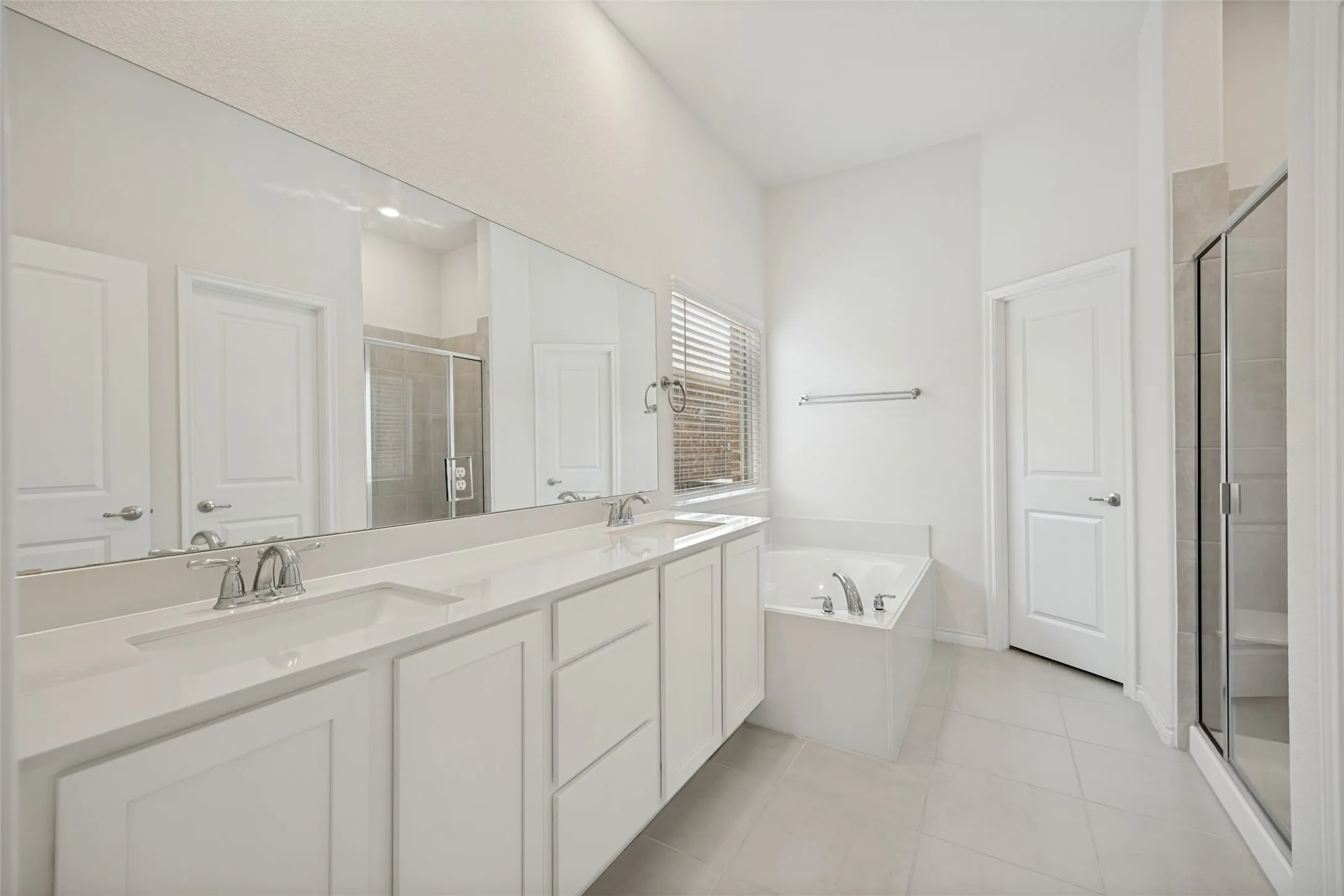 Dual vanity with white cabinetry, integrated sinks, and chrome fixtures