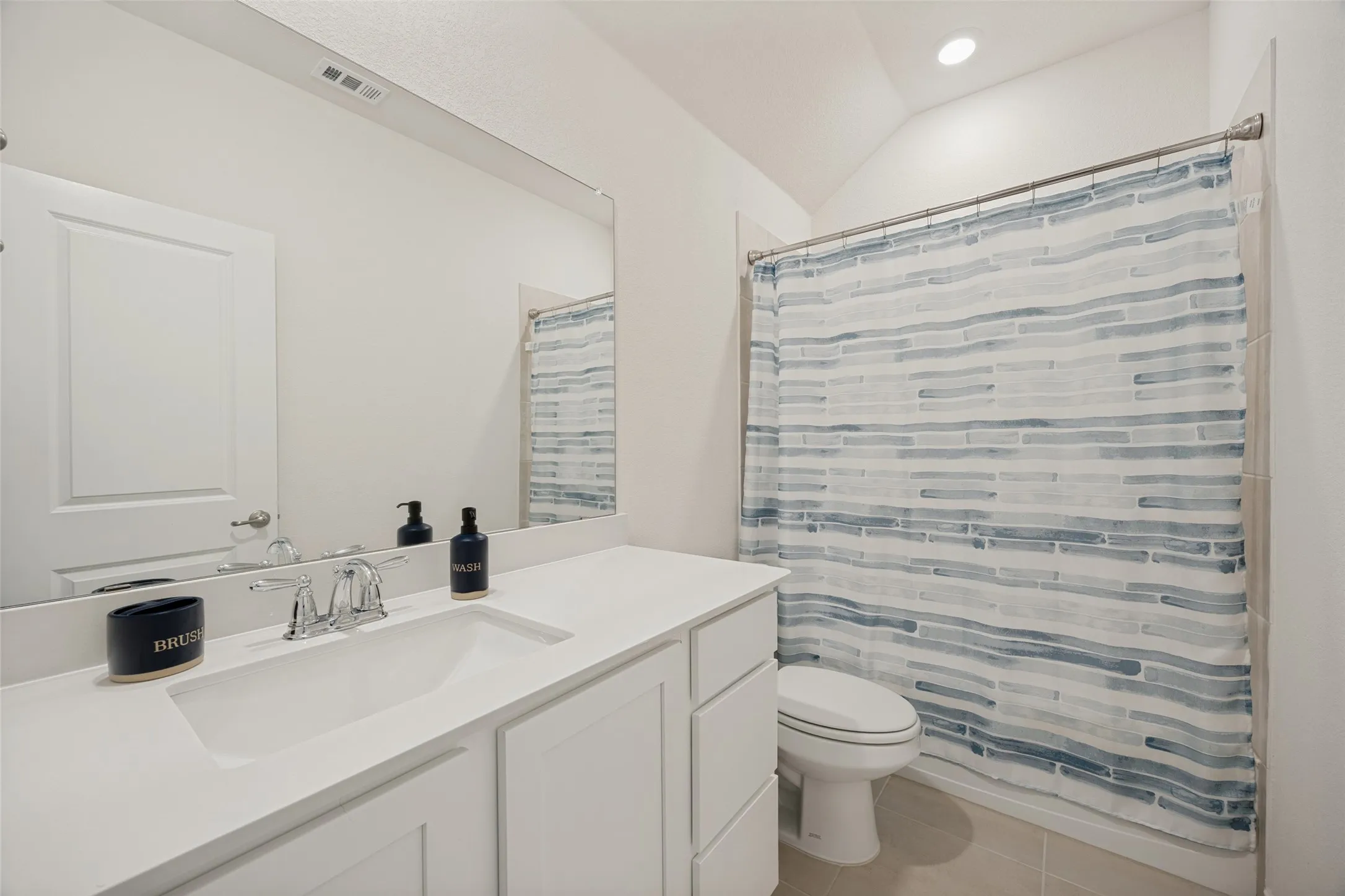 White vanity with an integrated sink, chrome faucet, and expansive wall-mounted mirror