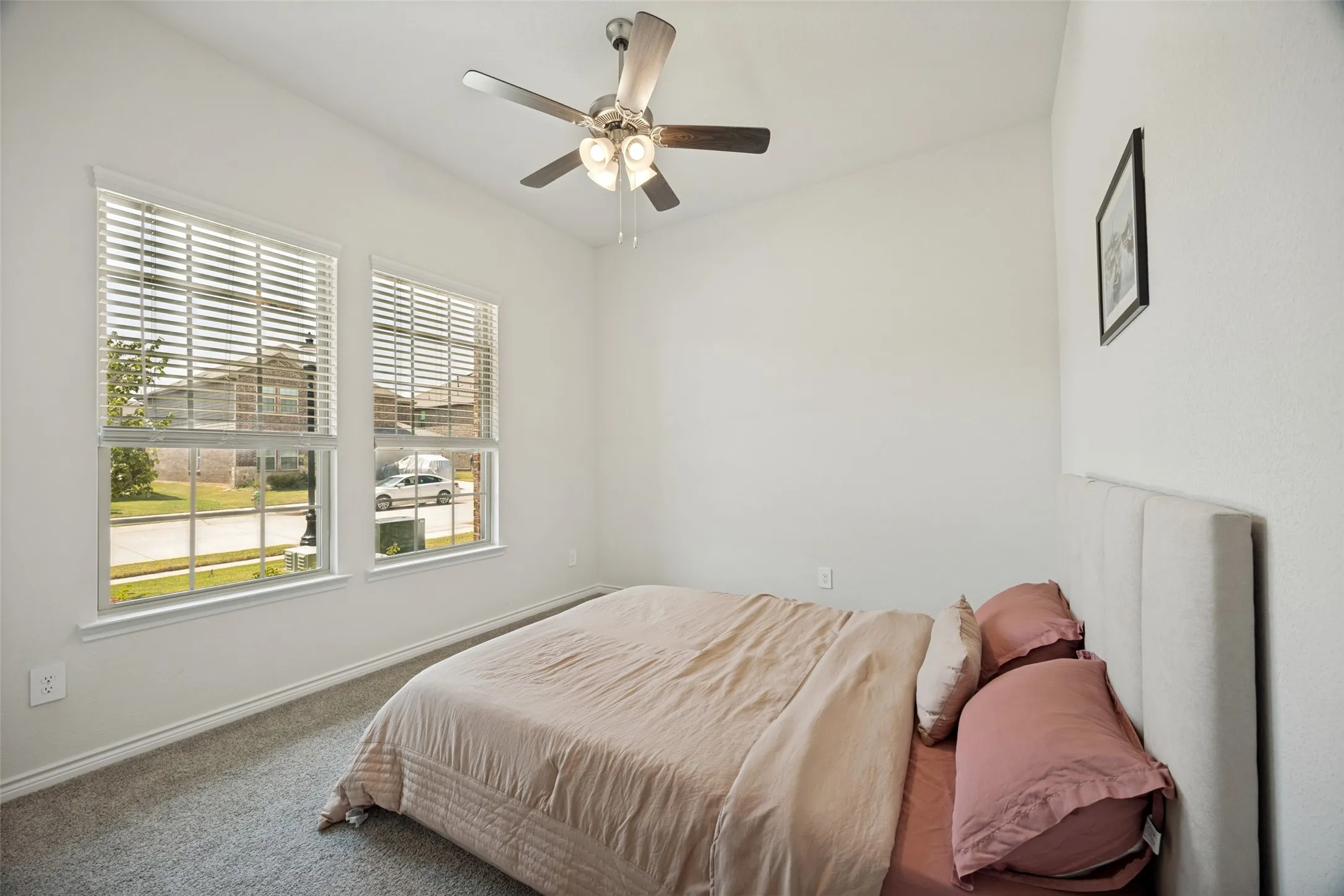 Carpeted room with vaulted ceiling and a ceiling fan with integrated lighting