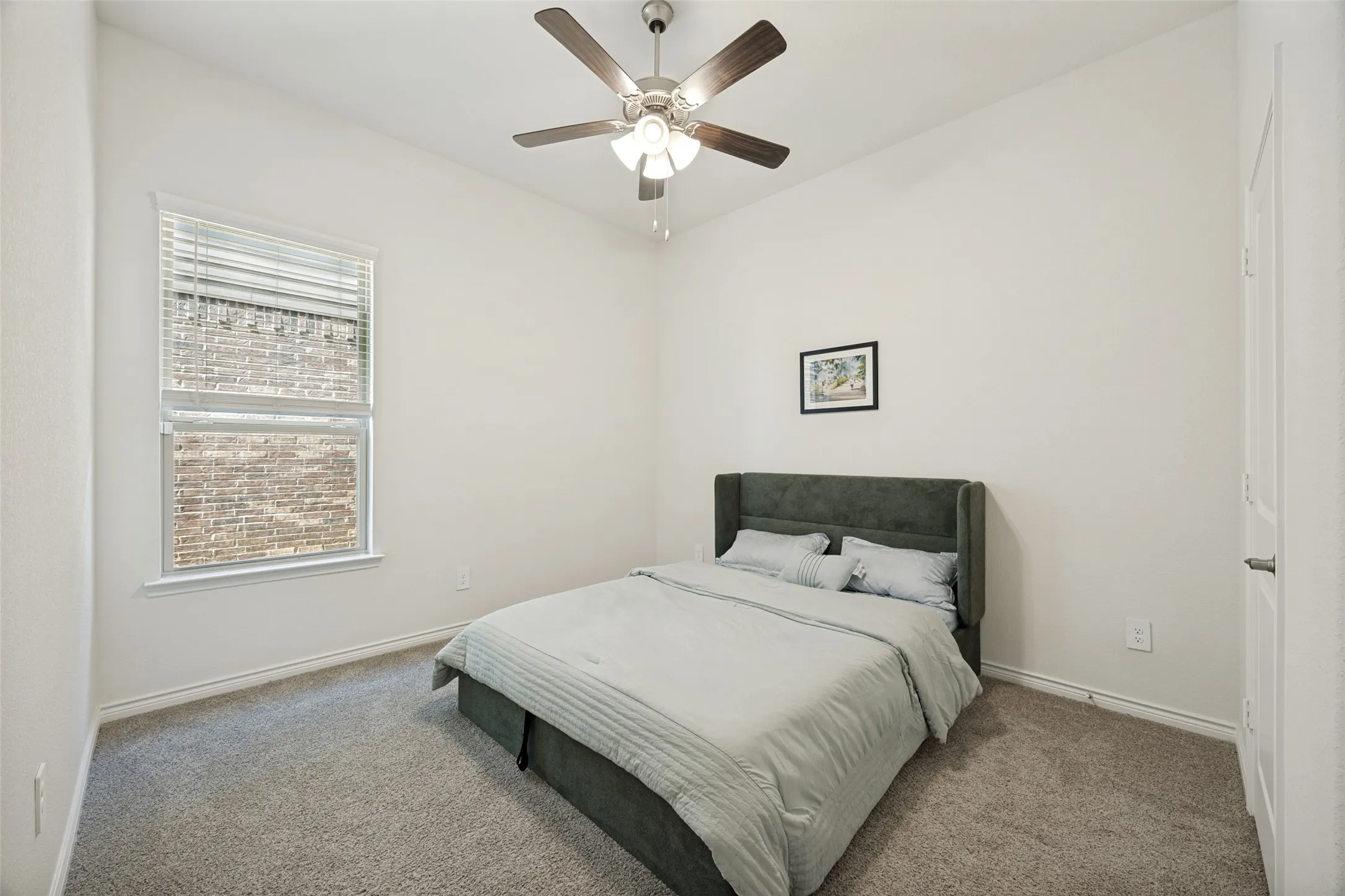 Carpeted flooring, vaulted ceiling, white walls, ceiling fan with light fixture, and window with blinds