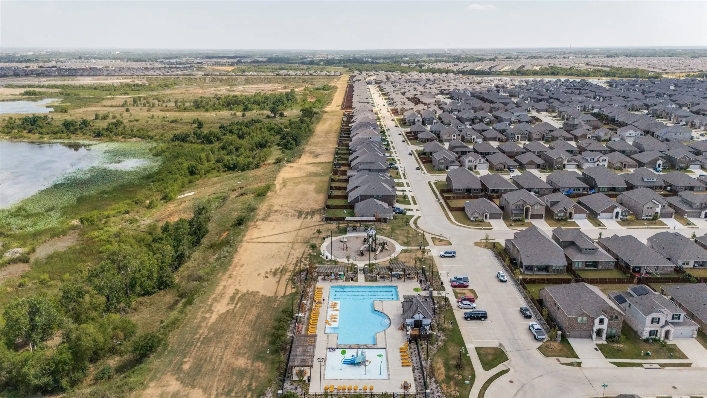 Residential community with multiple single-family homes, a communal swimming pool, and a children's play area