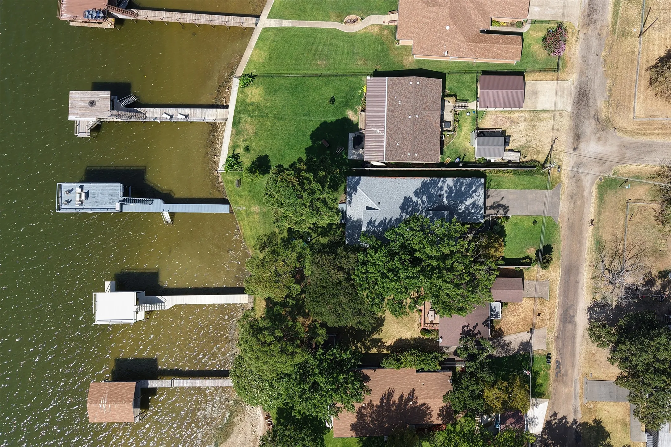 Waterfront property featuring multiple private docks and mature trees