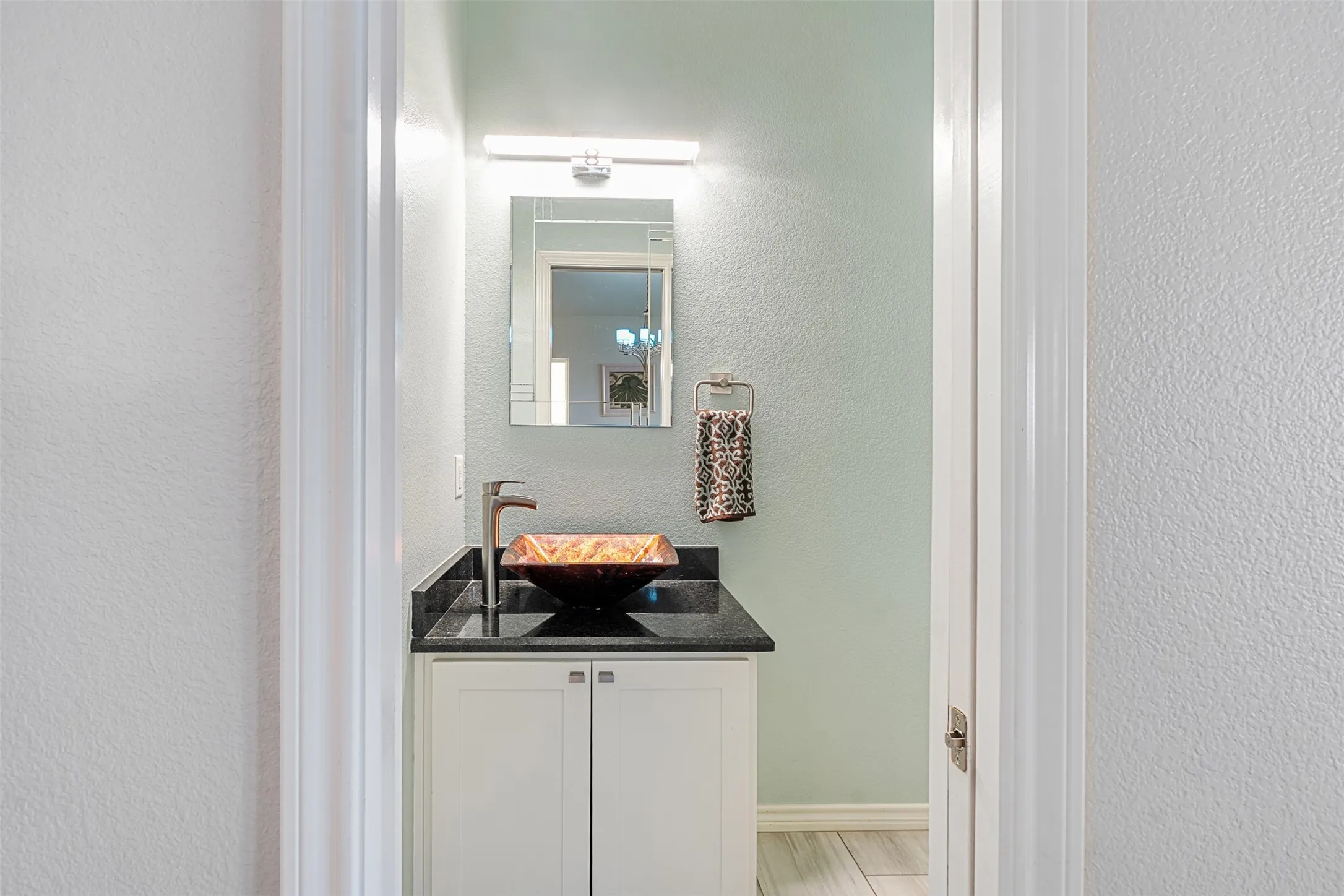 1/2 Bath White vanity cabinet with dark countertop, sink
