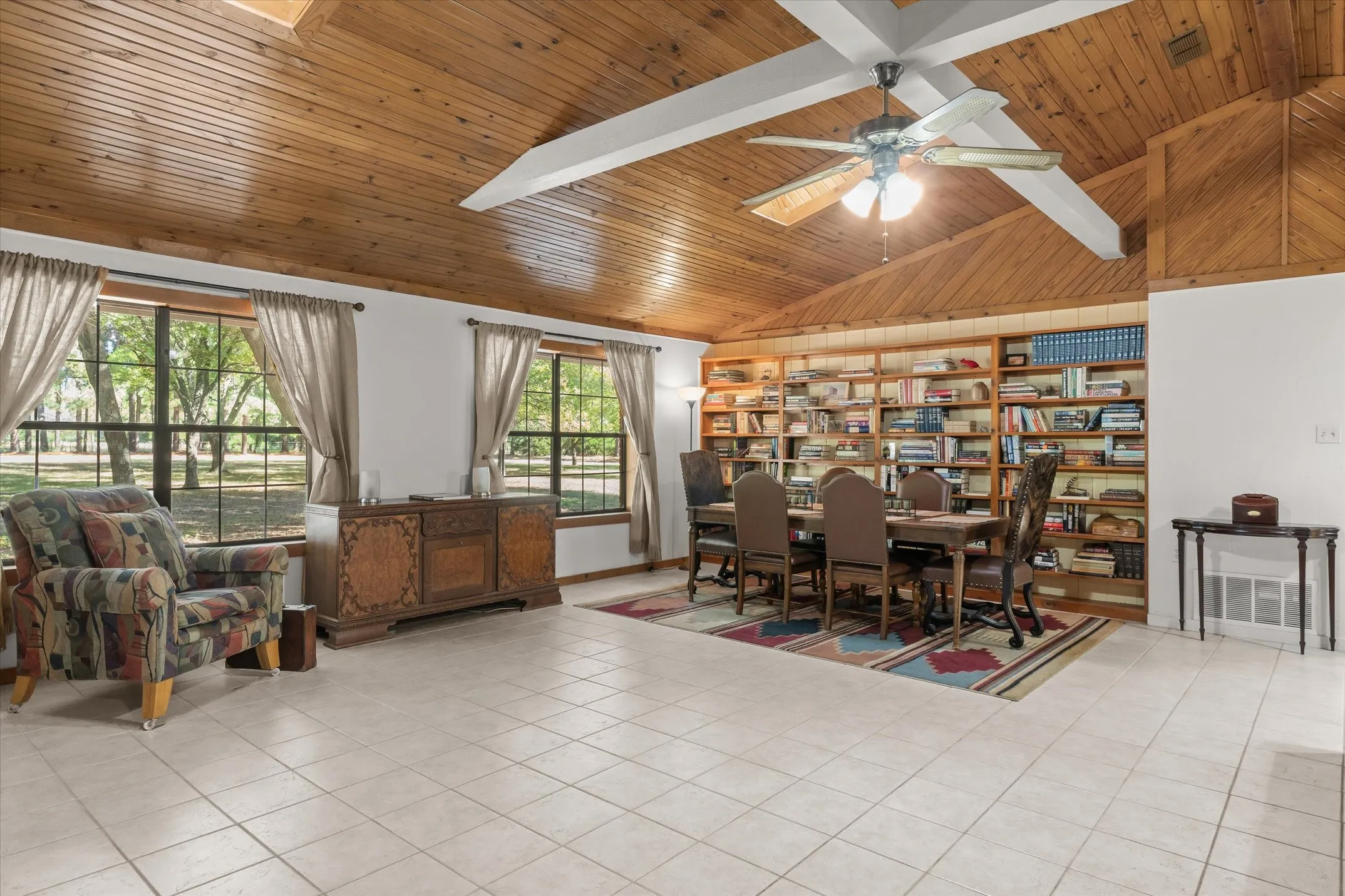 Large windows have views of the tree groves in the yard.