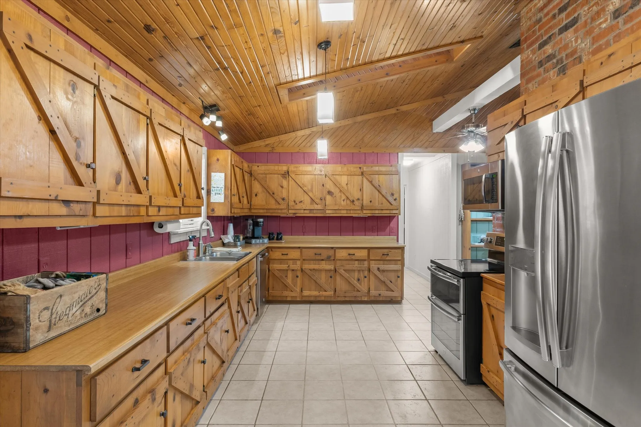 A true homesteader's large kitchen with shaker style cabinetry, stainless appliances, a skylight for extra natural light