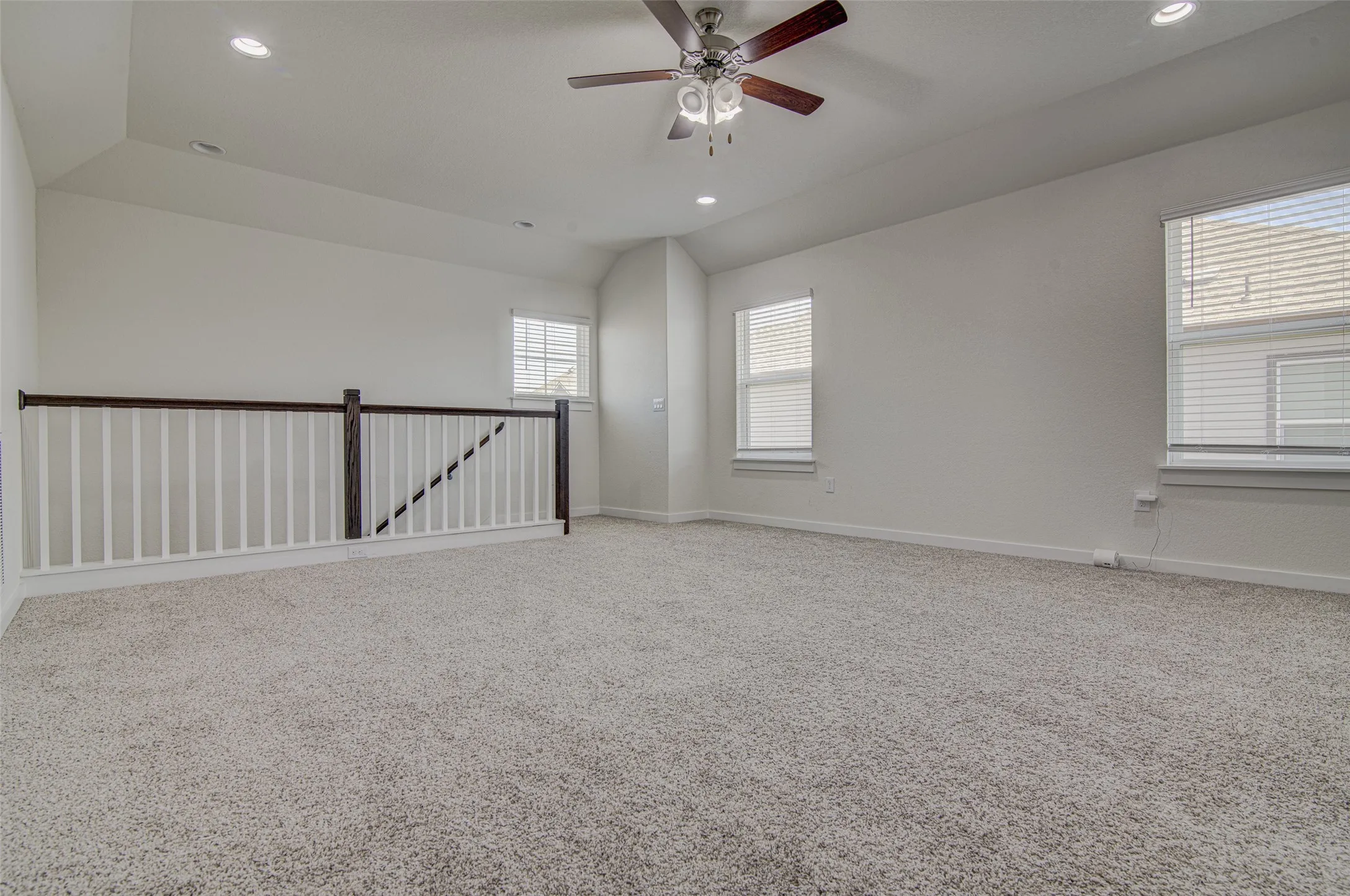 Vaulted ceiling with recessed lighting and ceiling fan, carpeted flooring, and white painted walls