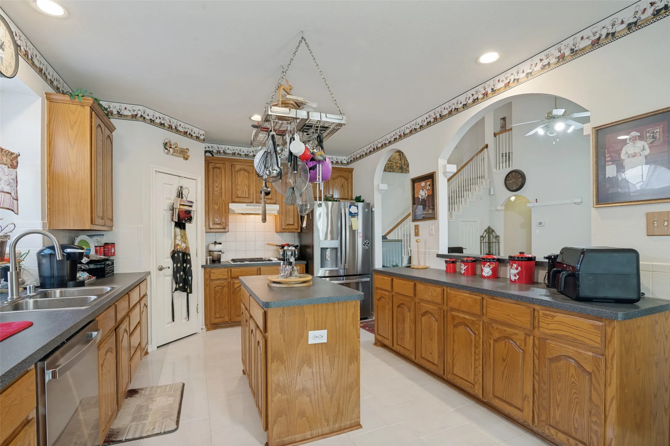 Kitchen with wood-finish cabinetry, stainless steel appliances, a center island, and recessed lighting