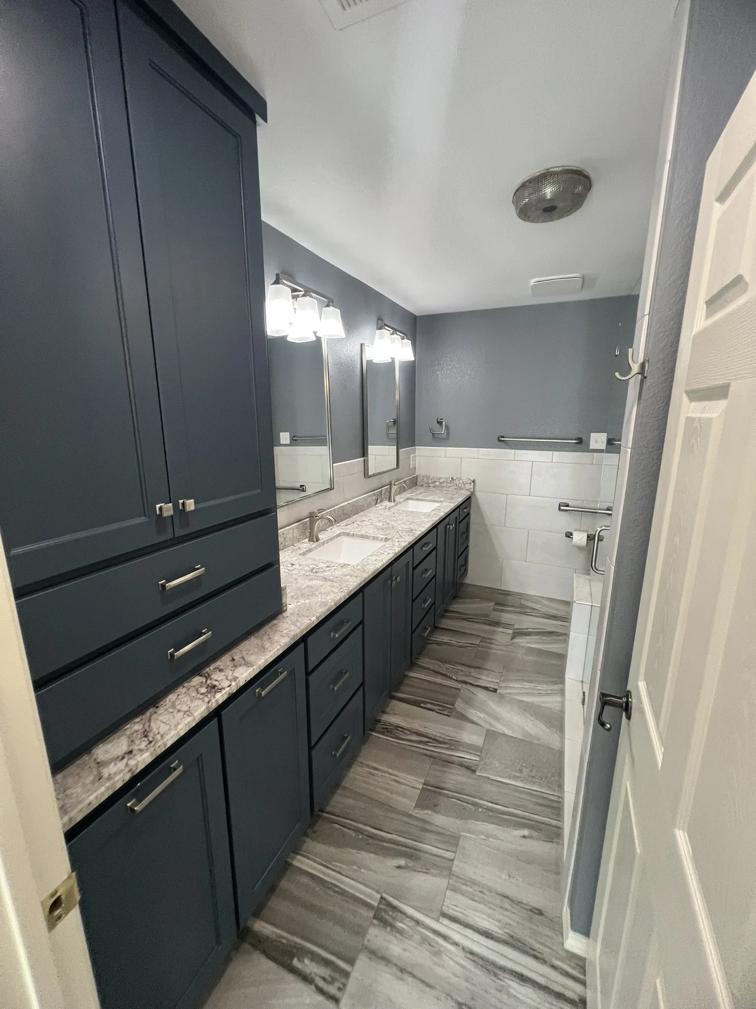 Master Bath Dual vanity with undermount sinks, stone countertops, and dark cabinetry