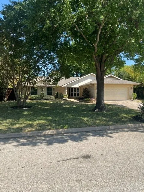 Single-story residence featuring a brick exterior and an attached garage