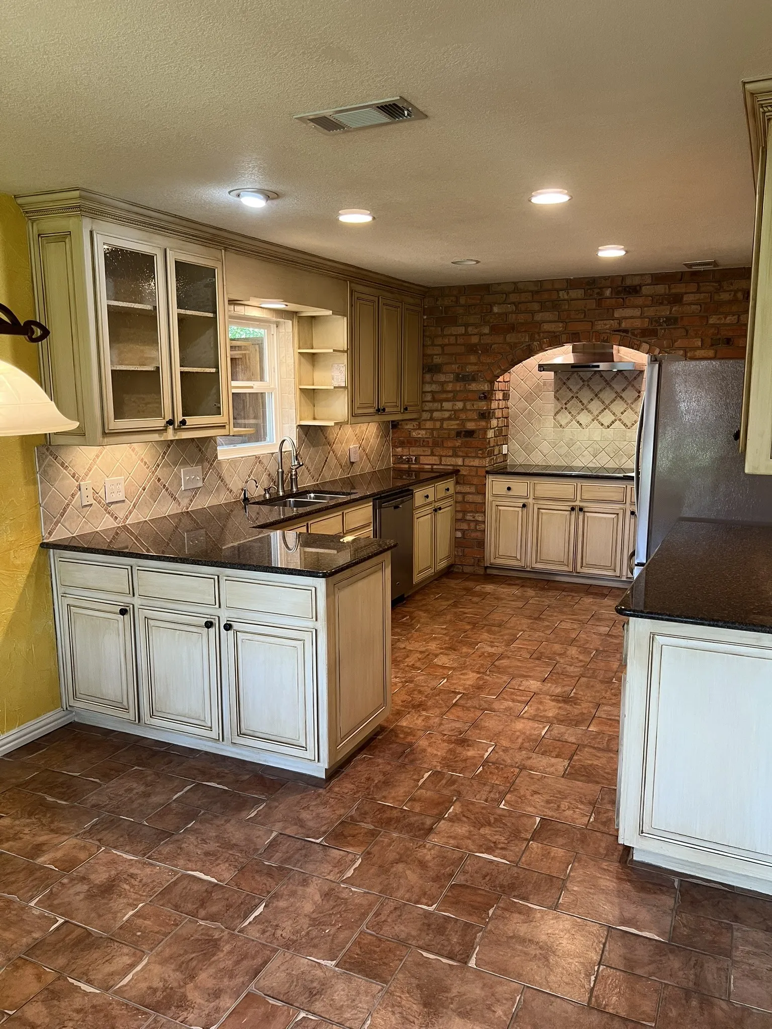 Kitchen featuring ample cabinetry, stone countertops, a tile backsplash, and ceramic tile flooring