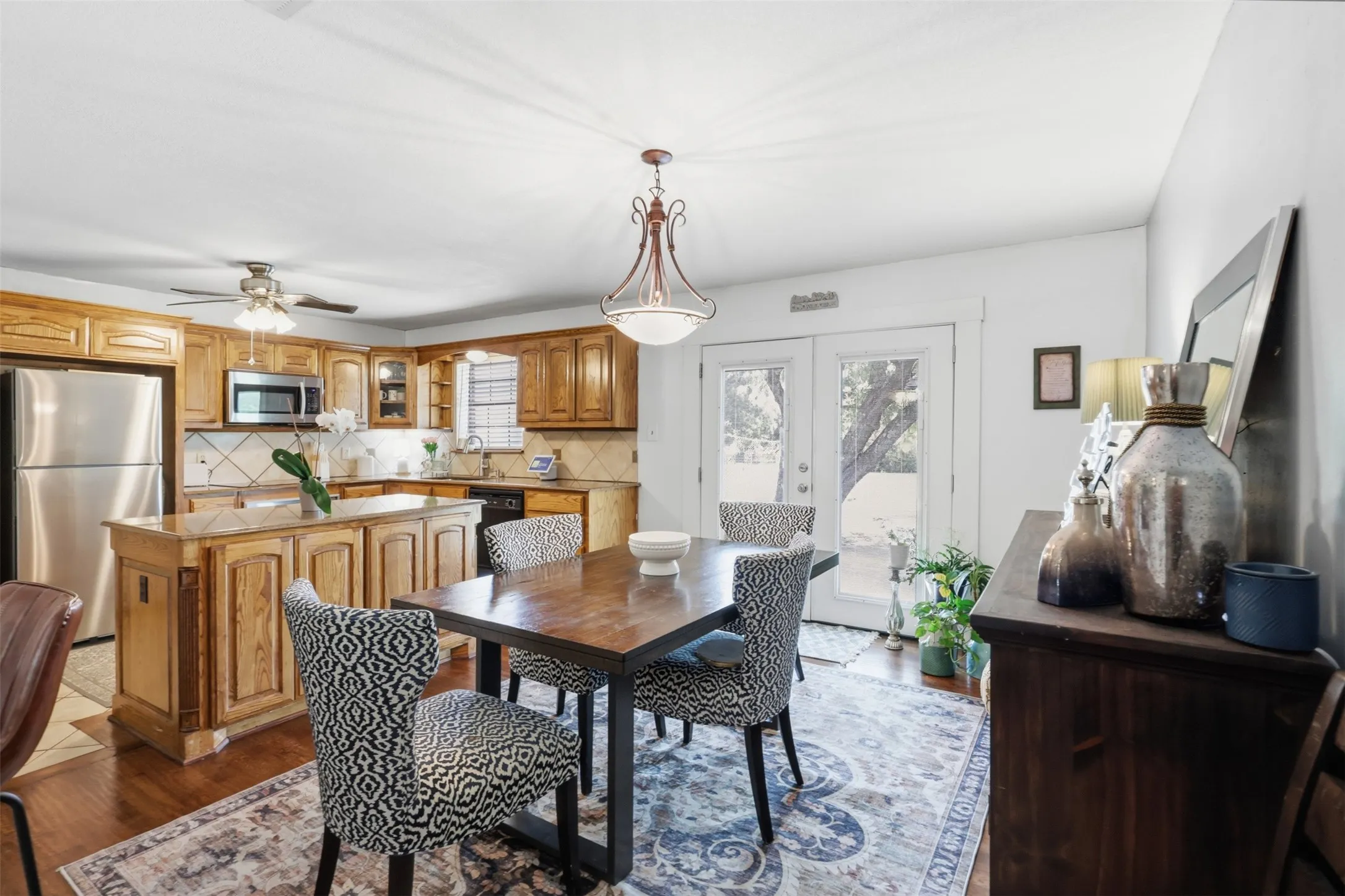 Kitchen featuring wood-finish cabinetry, stainless steel appliances, and a central island with stone-finish countertop