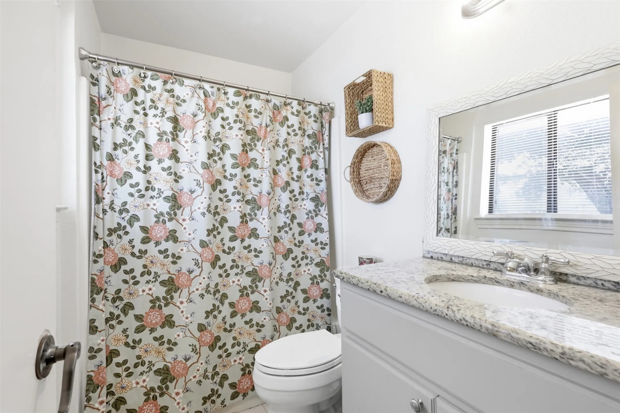 White vanity with a light granite countertop, undermount sink, and polished chrome faucet