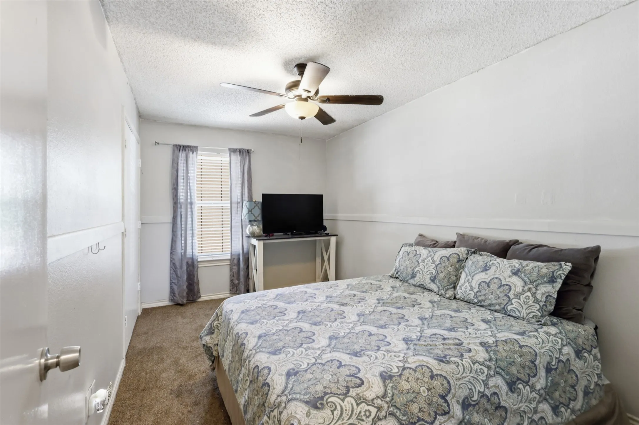 Ceiling fan with integrated lighting, window with blinds, and wall-to-wall carpeting