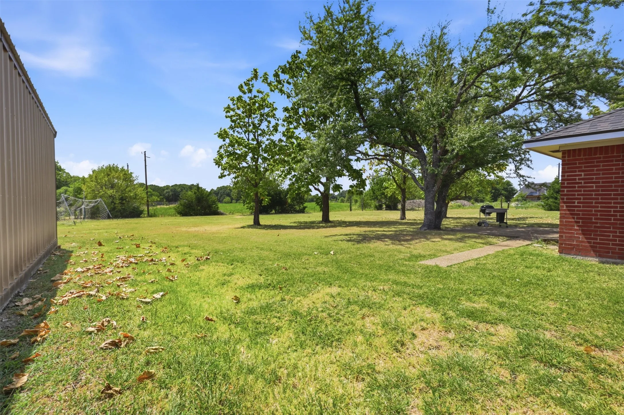 Expansive grassy yard with mature trees