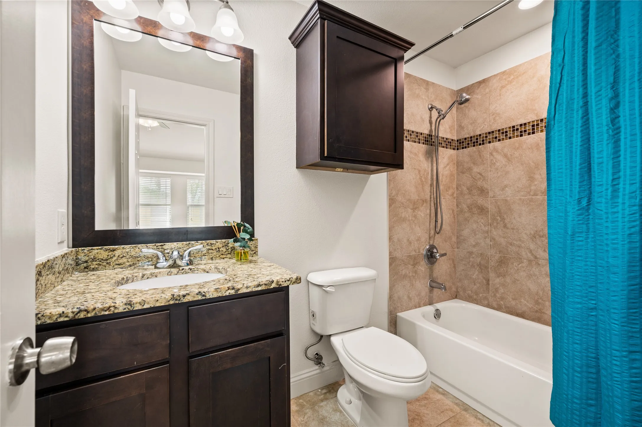Vanity with a granite countertop, undermount sink, and dark wood-finish cabinetry