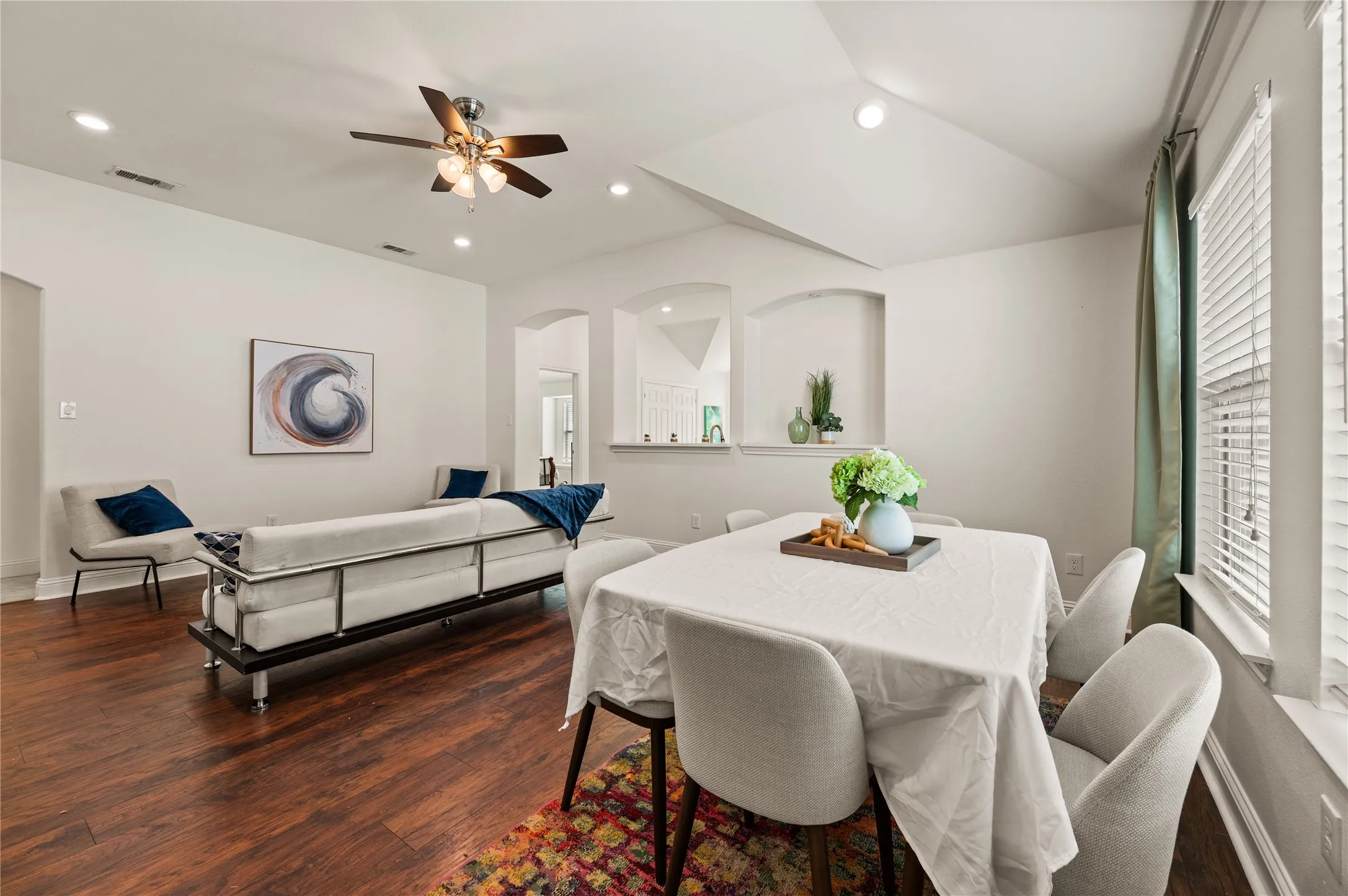 Wood-finish flooring throughout, vaulted ceiling, recessed lighting, and a ceiling fan with light fixture