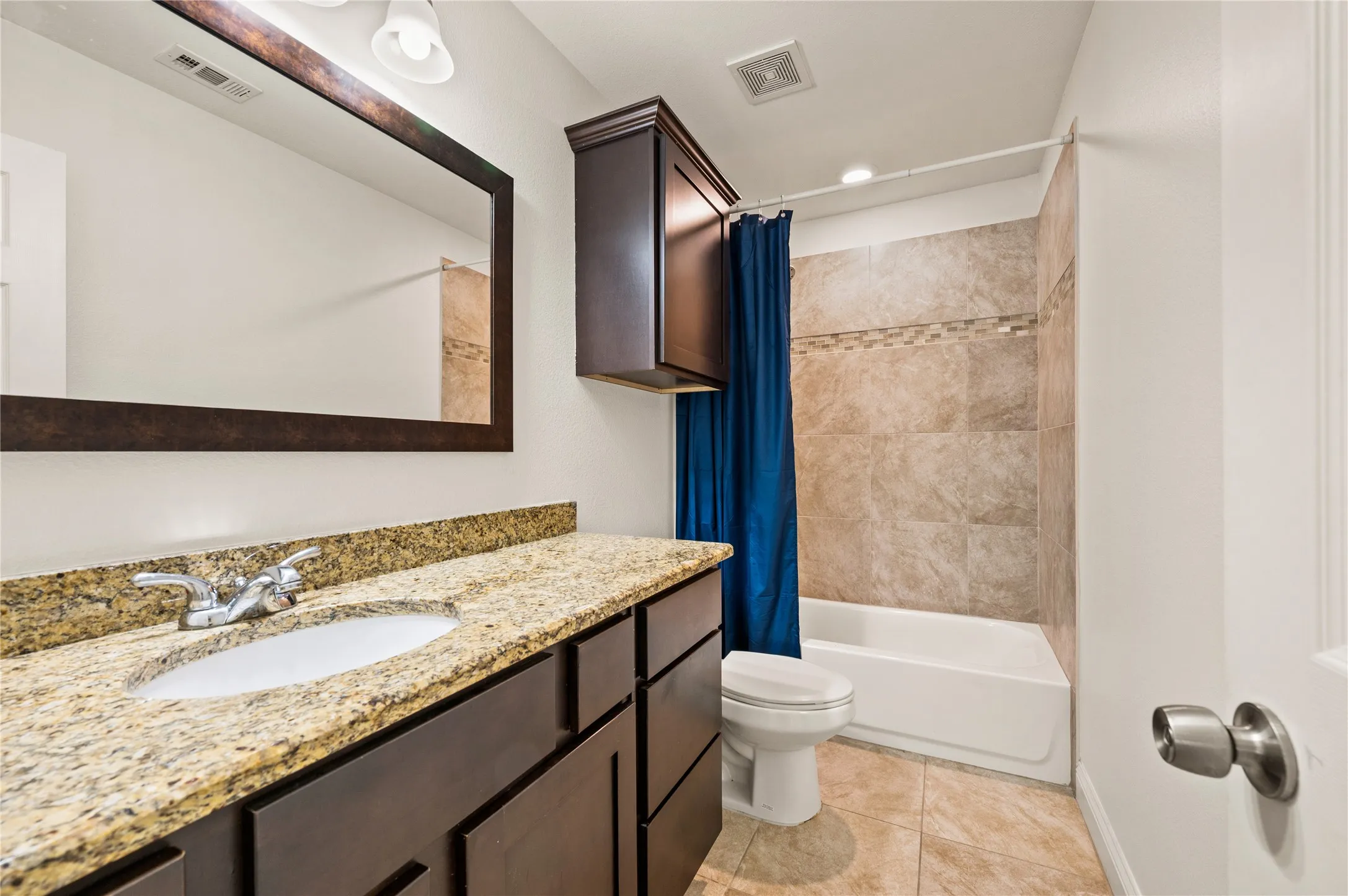 Vanity with a granite countertop, undermount sink, and dark wood cabinetry